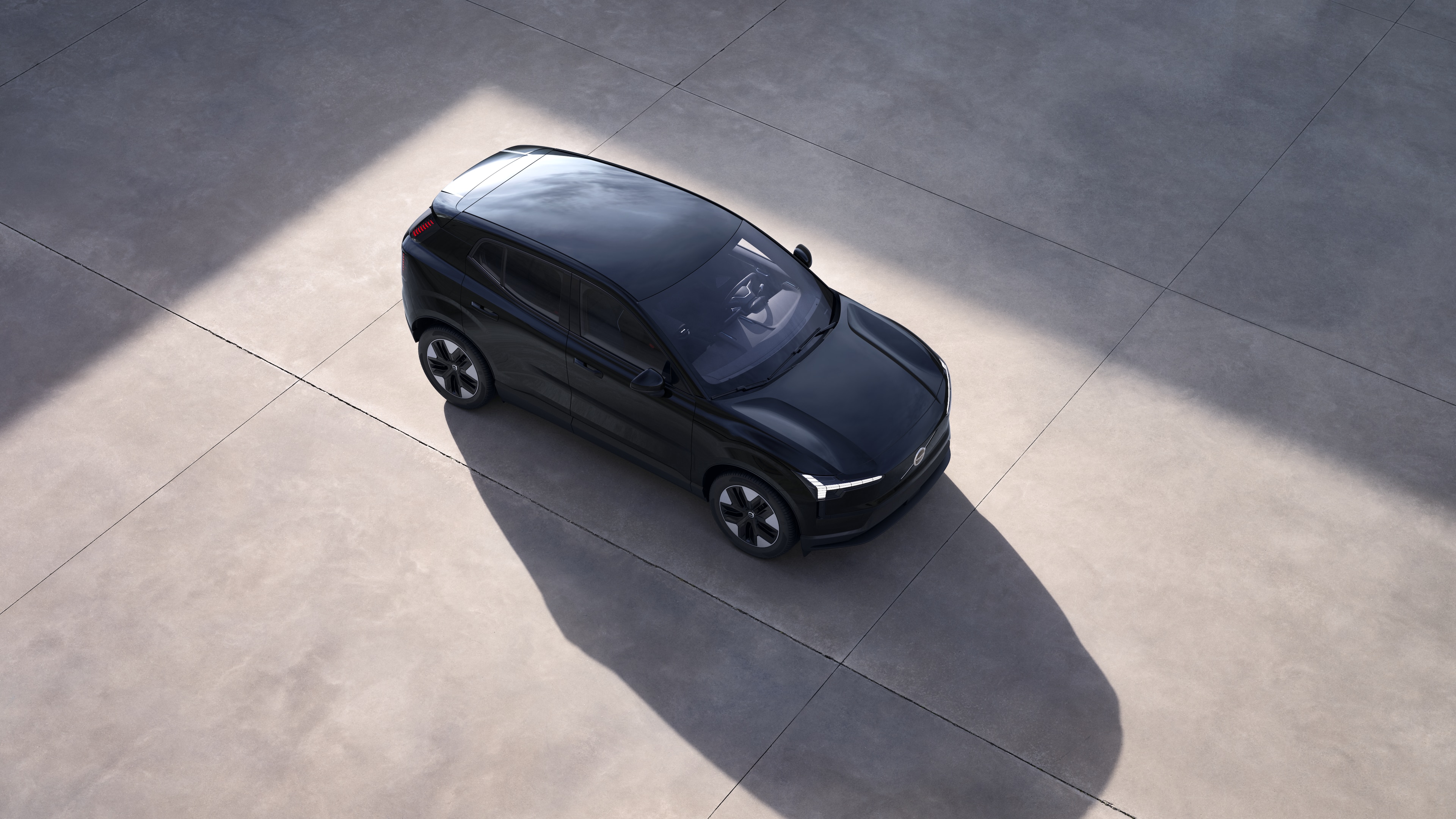 El exterior del vehículo Volvo se muestra desde arriba en un fondo de estudio liso.