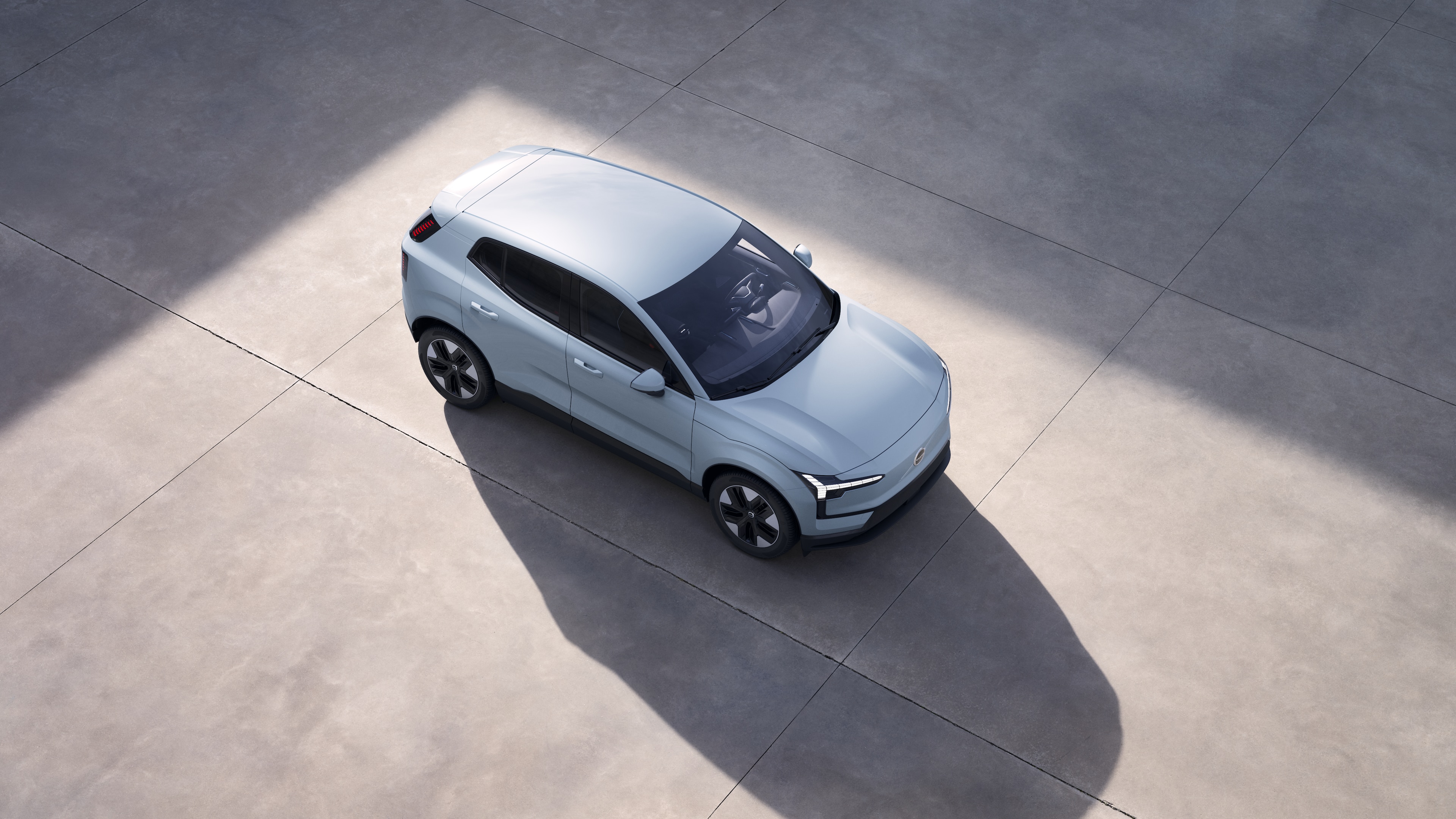 El exterior del vehículo Volvo se muestra desde arriba en un fondo de estudio liso.