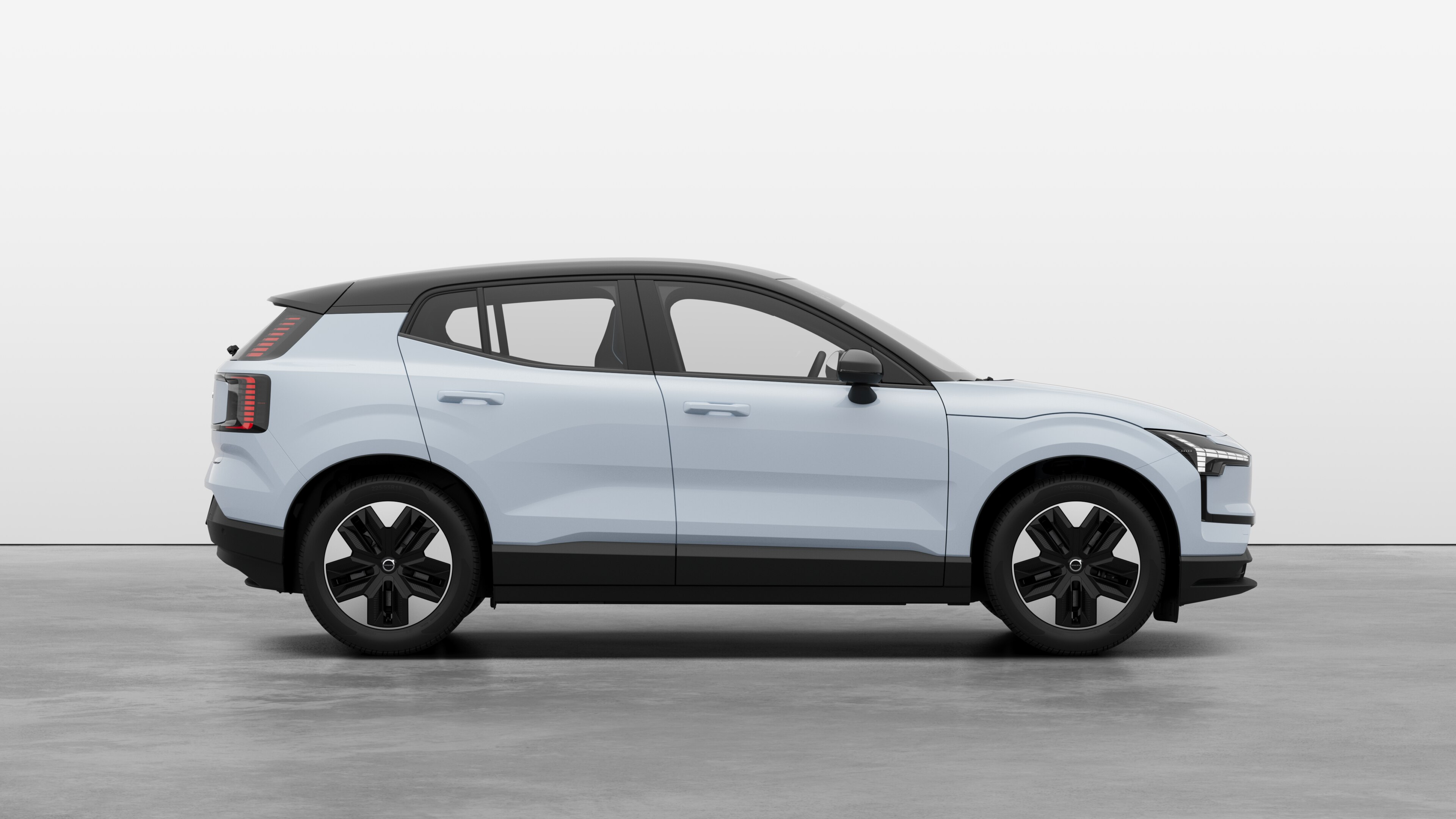 Volvo car side view on plain studio background displaying closed doors and visible wheel design.