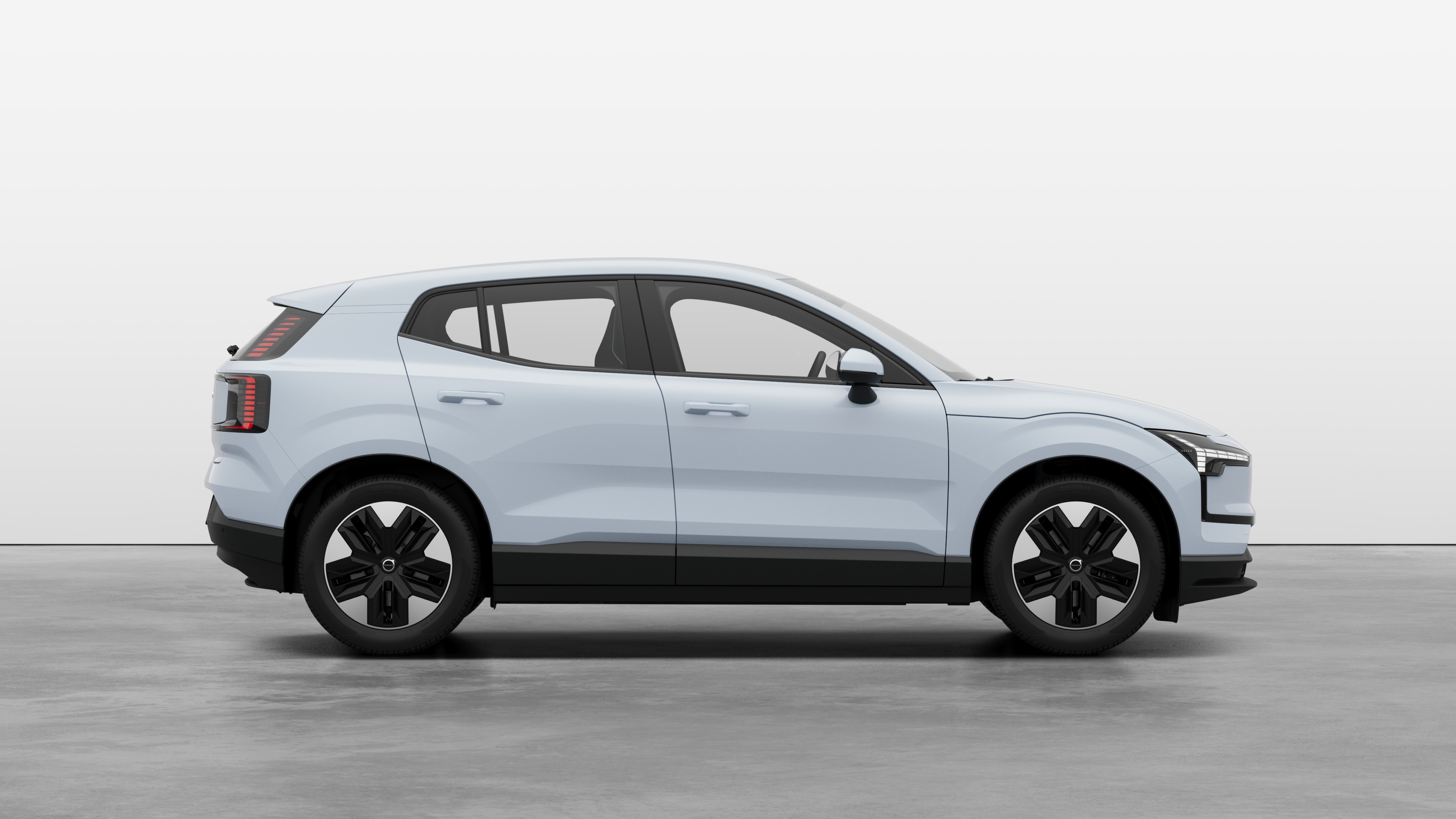 Volvo car side view on plain studio background displaying closed doors and visible wheel design.