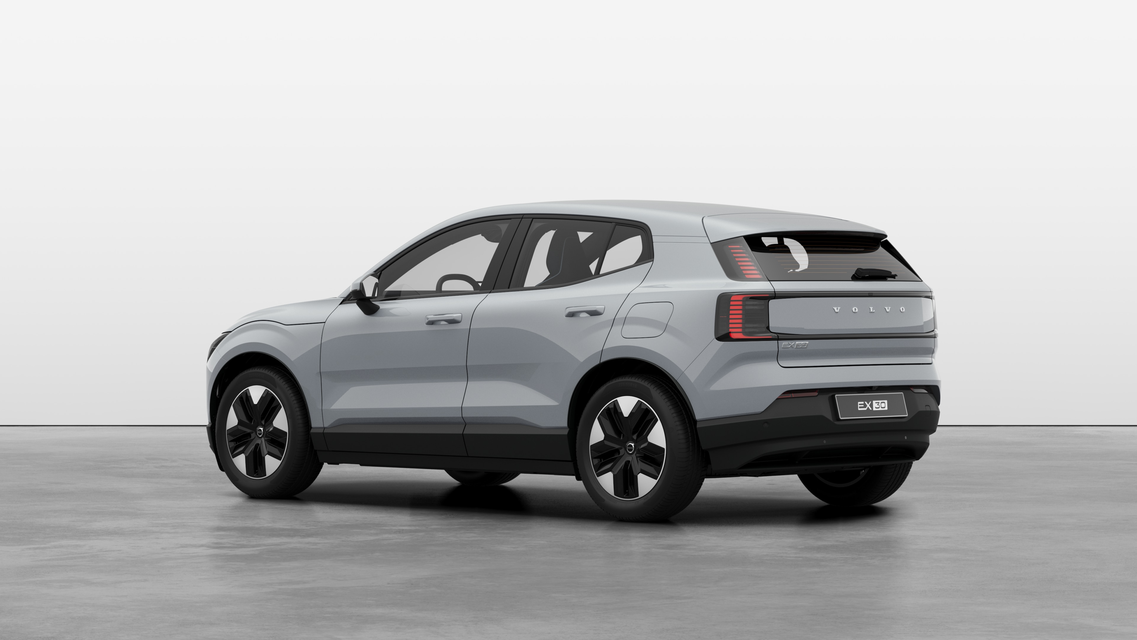 Vista traseira de três quartos do carro Volvo em um fundo de estúdio simples.