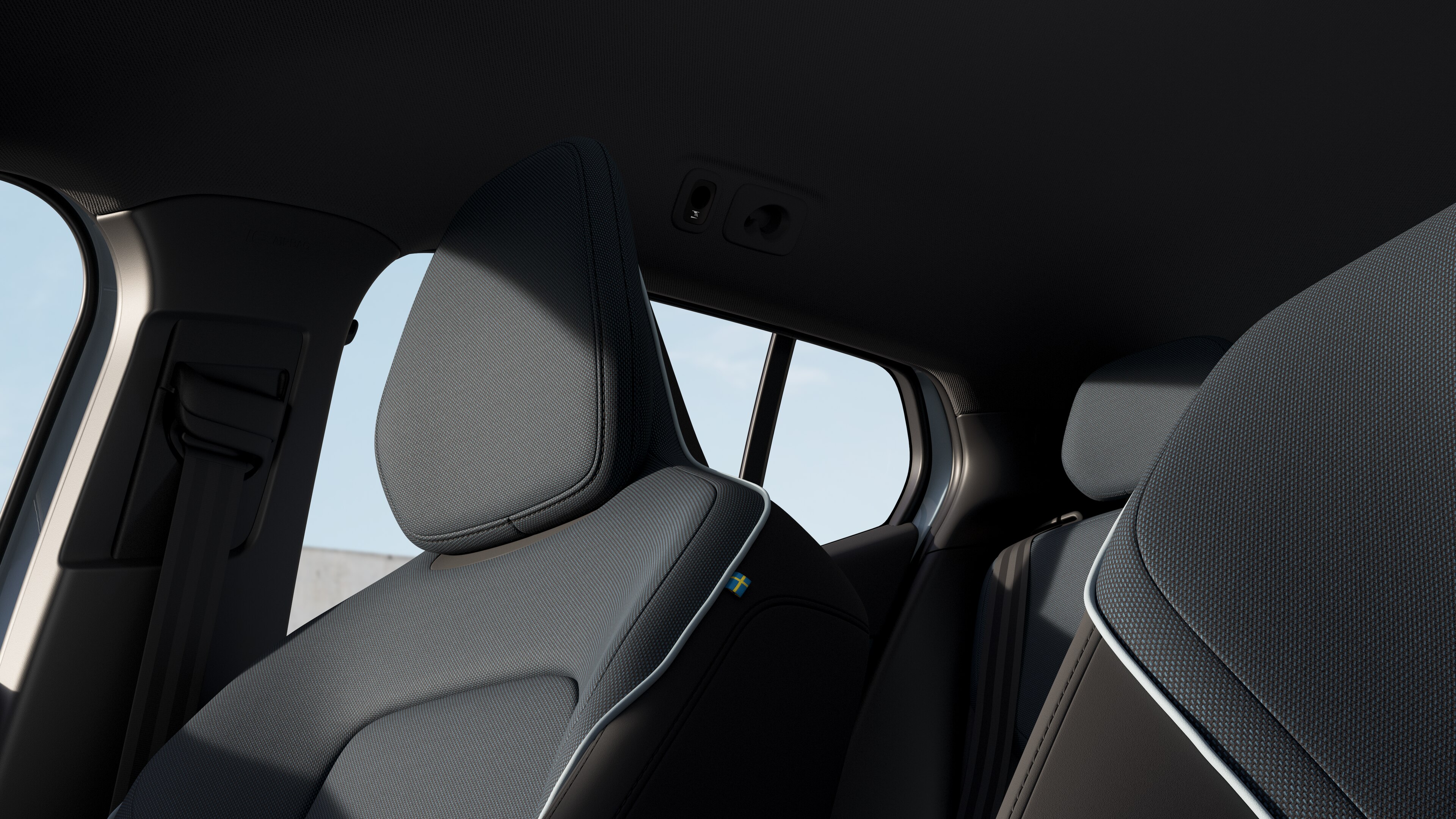 Volvo car interior showing front and rear passenger seats, steering wheel, dashboard, and center console against a plain studio background.