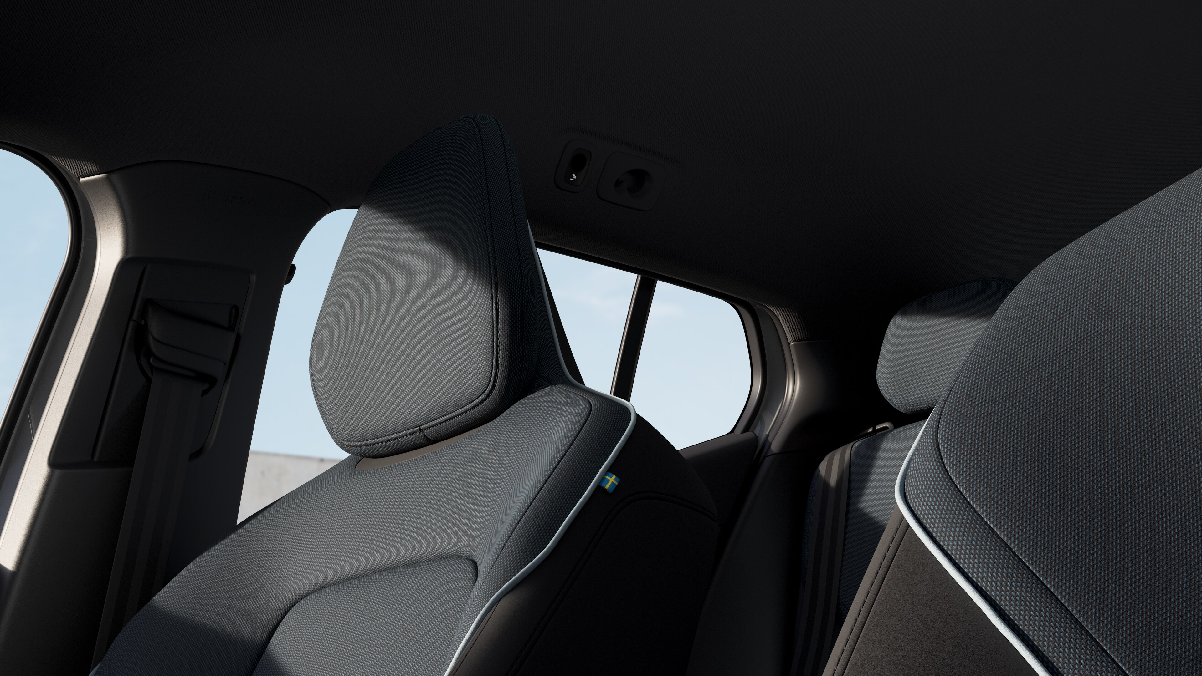 Interior do carro Volvo mostrando os bancos dianteiros e traseiros do passageiro, volante, painel de instrumentos e console central contra um plano de fundo de estúdio.