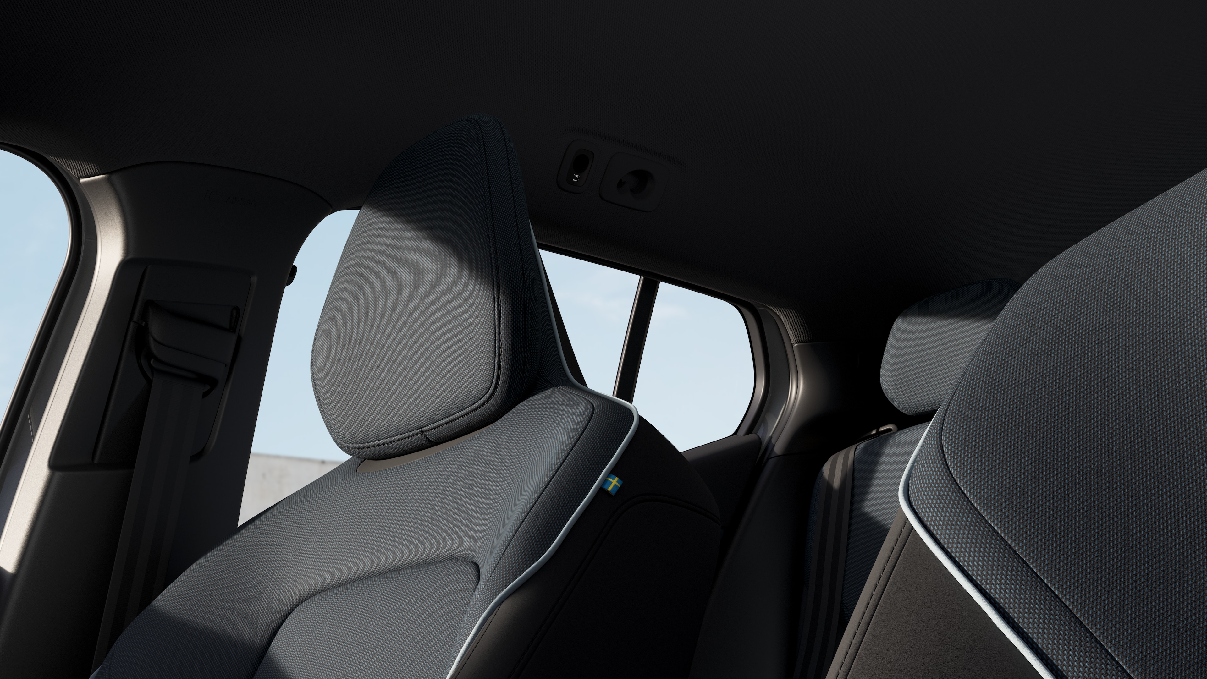 Interior do carro Volvo mostrando os bancos dianteiros e traseiros do passageiro, volante, painel de instrumentos e console central contra um plano de fundo de estúdio.