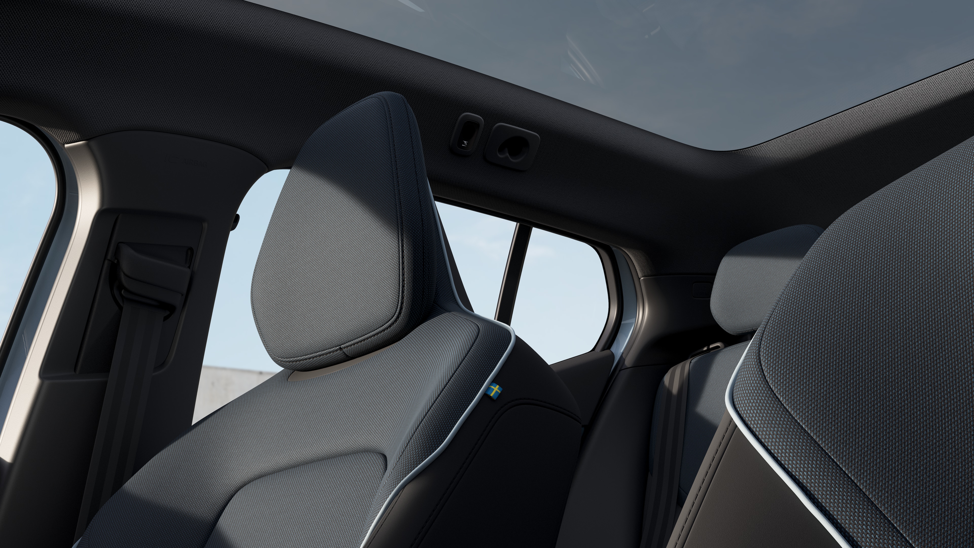 Volvo car interior showing front and rear passenger seats, steering wheel, dashboard, and center console against a plain studio background.