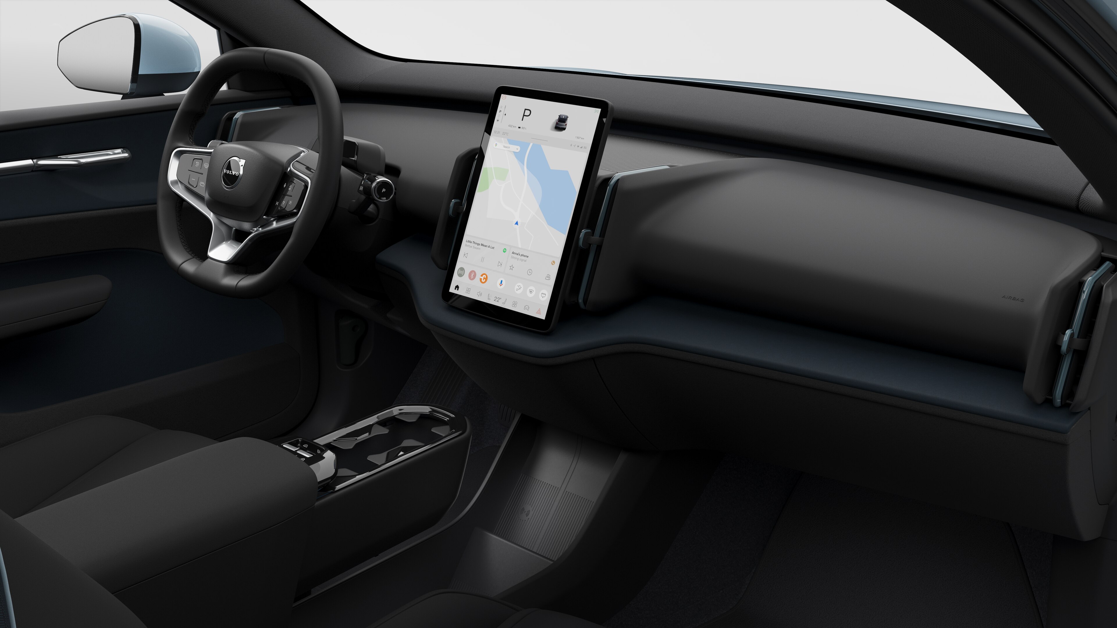 Interior view of a Volvo car showing the dashboard, steering wheel, center console, and digital display screen in a plain studio background.