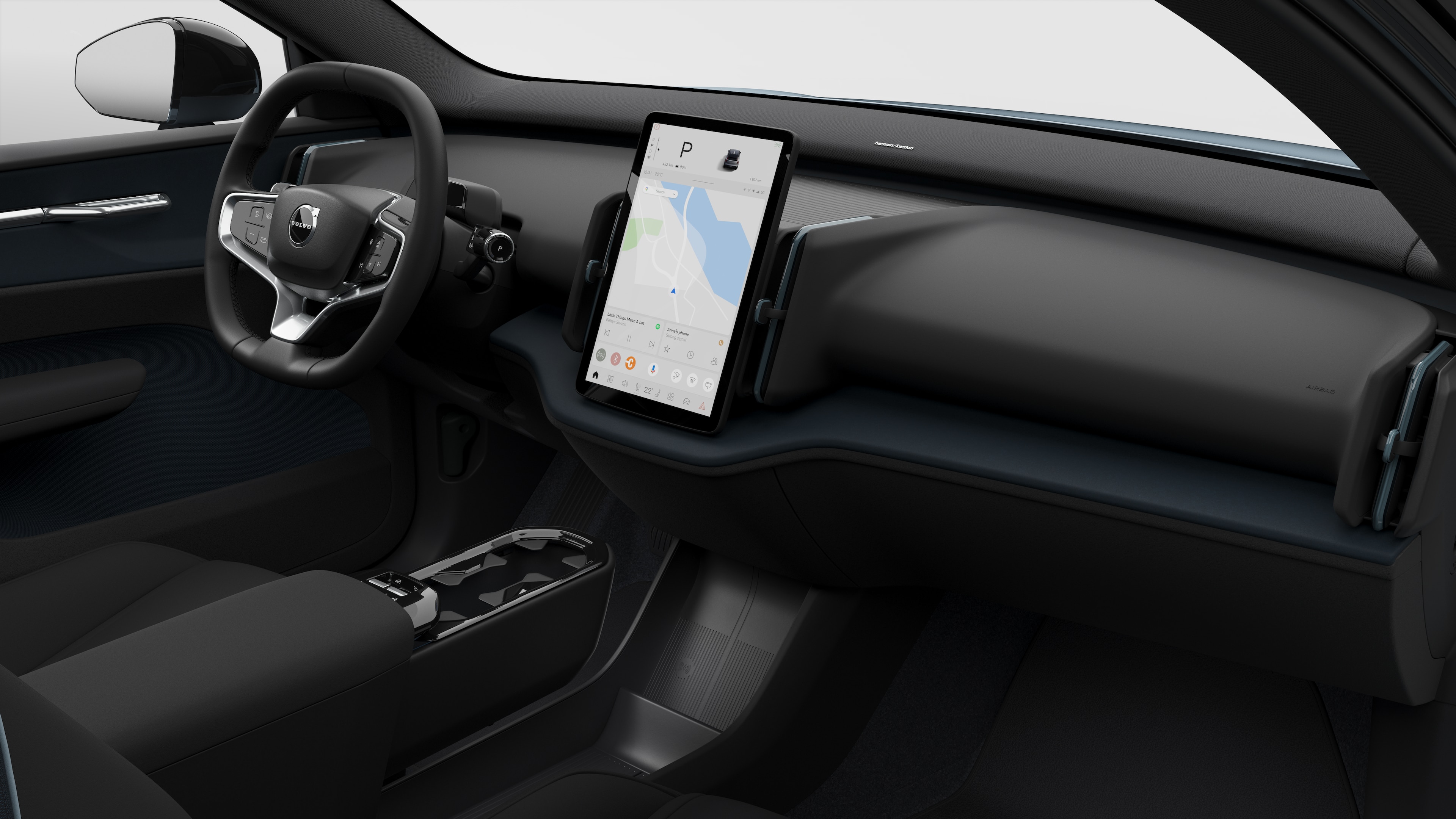 Vista interna de um carro Volvo mostrando o painel, o volante, o console central e a tela digital em um plano de fundo de estúdio simples.