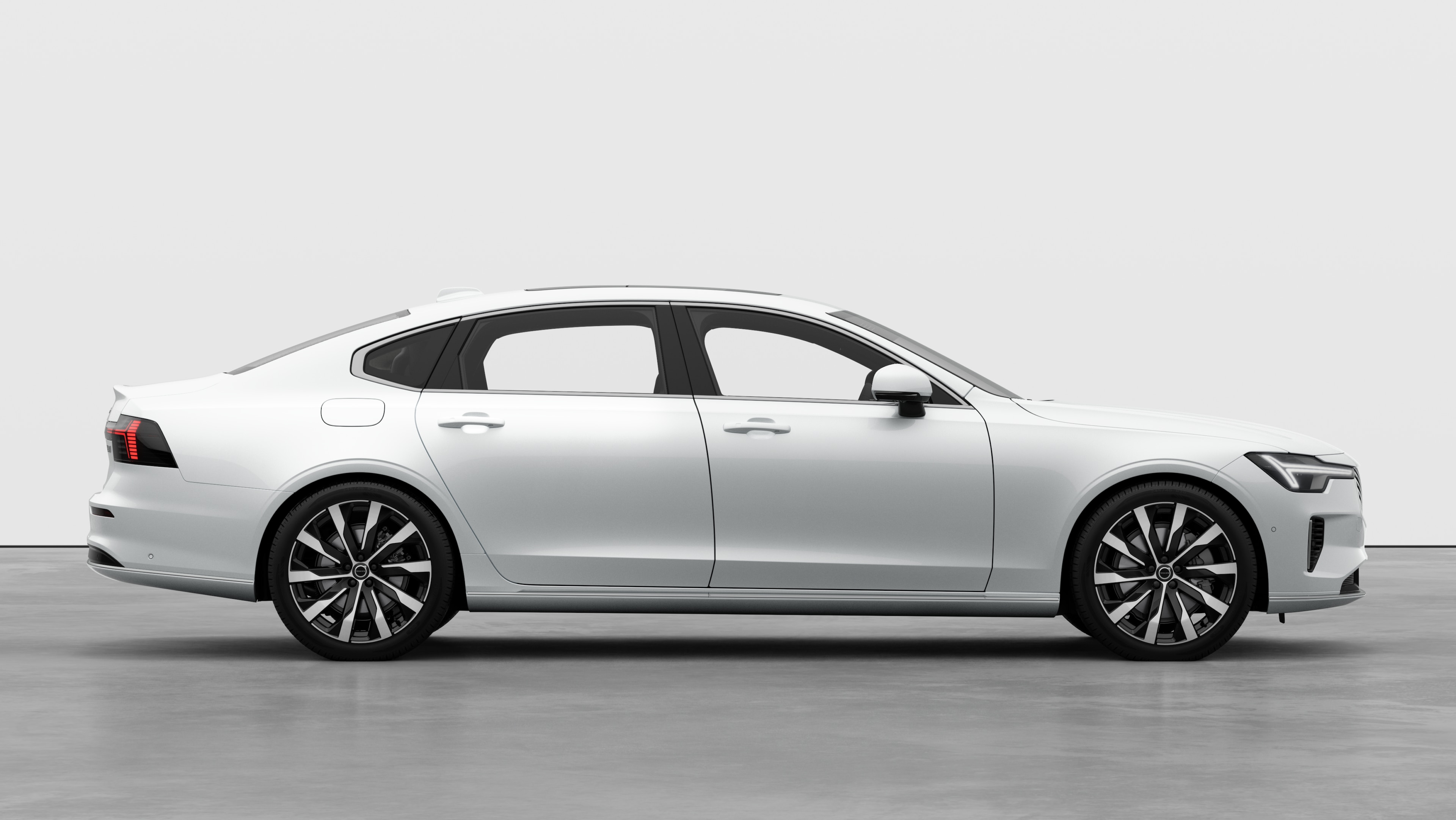 닫힌 문과 눈에 띄는 바퀴 디자인을 표시하는 평범한 스튜디오 배경에 볼보 자동차 측면도.