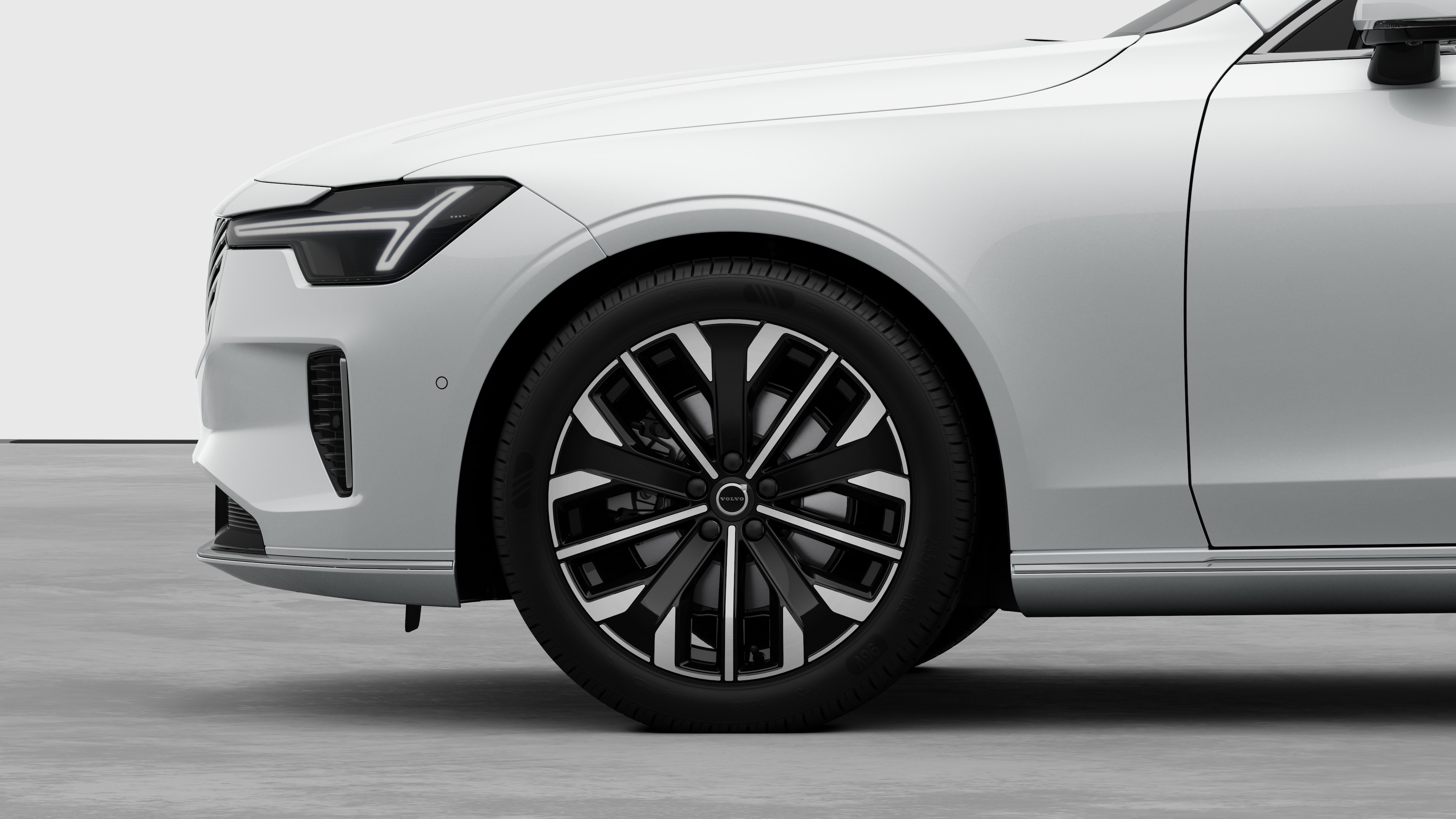 평범한 스튜디오 배경을 배경으로 앞바퀴와 펜더에 초점을 맞춘 볼보 자동차 외부 측면도.