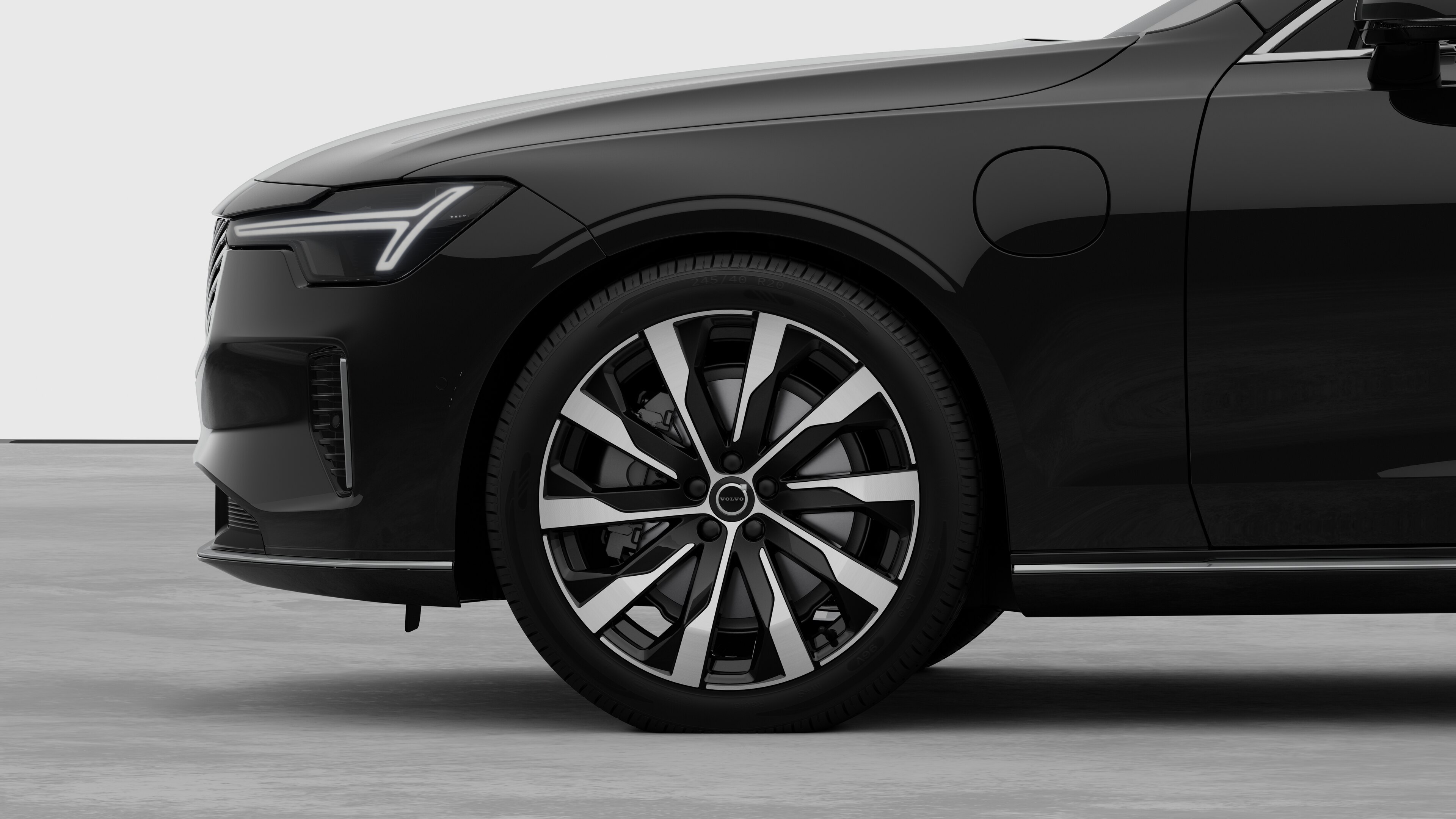 Volvo car exterior side view focusing on the front wheel and fender, set against a plain studio background.