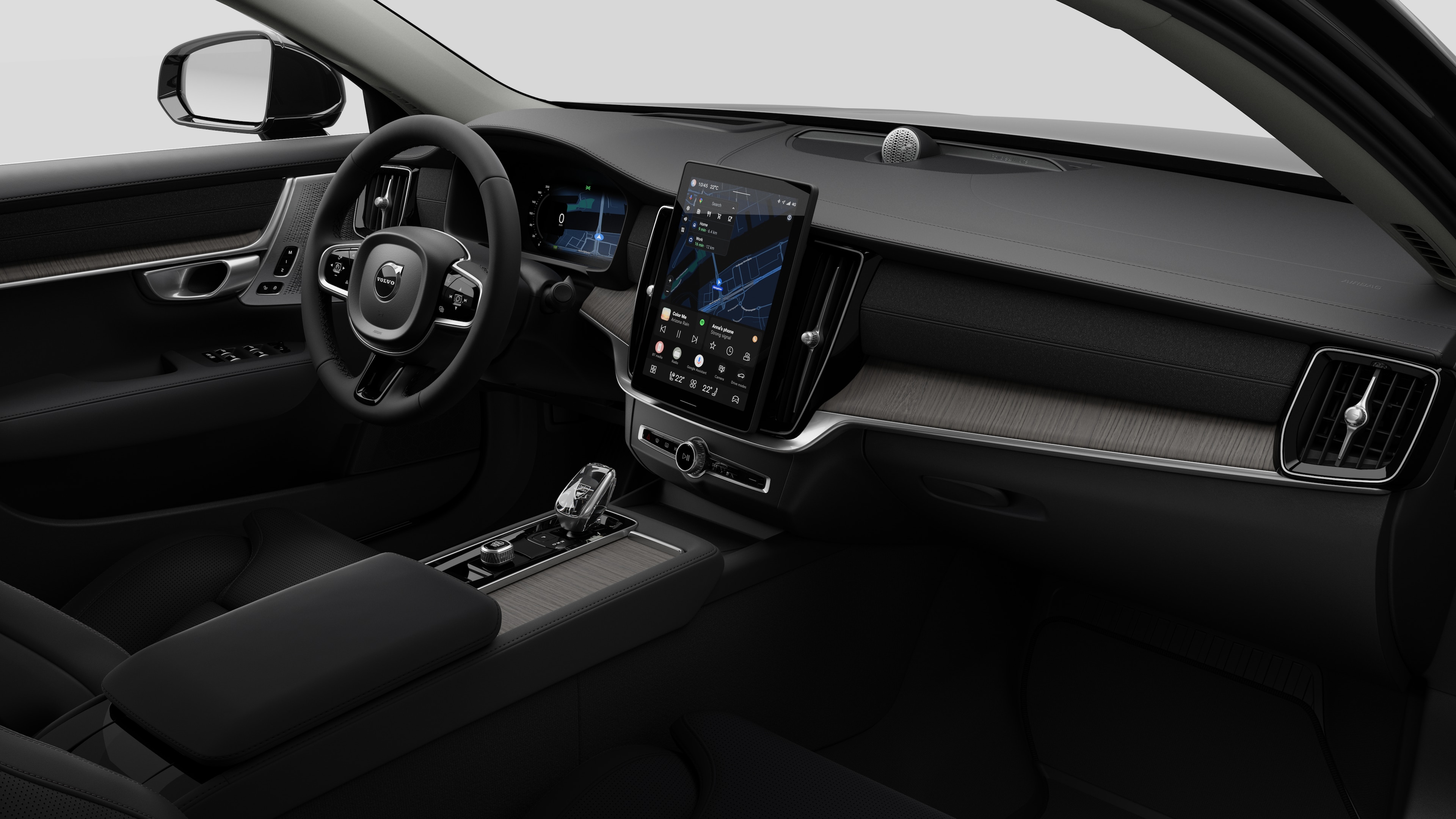 Interior view of a Volvo car showing the dashboard, steering wheel, center console, and digital display screen in a plain studio background.