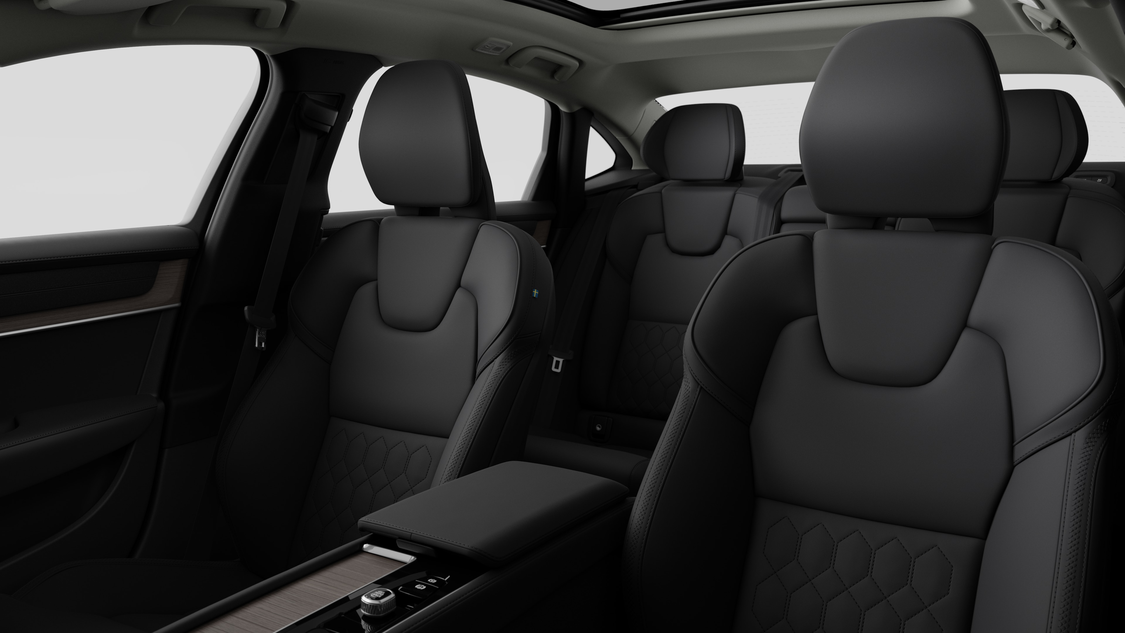 평범한 스튜디오 배경에 뒷좌석 조수석과 중앙 콘솔을 보여주는 볼보 자동차 내부.