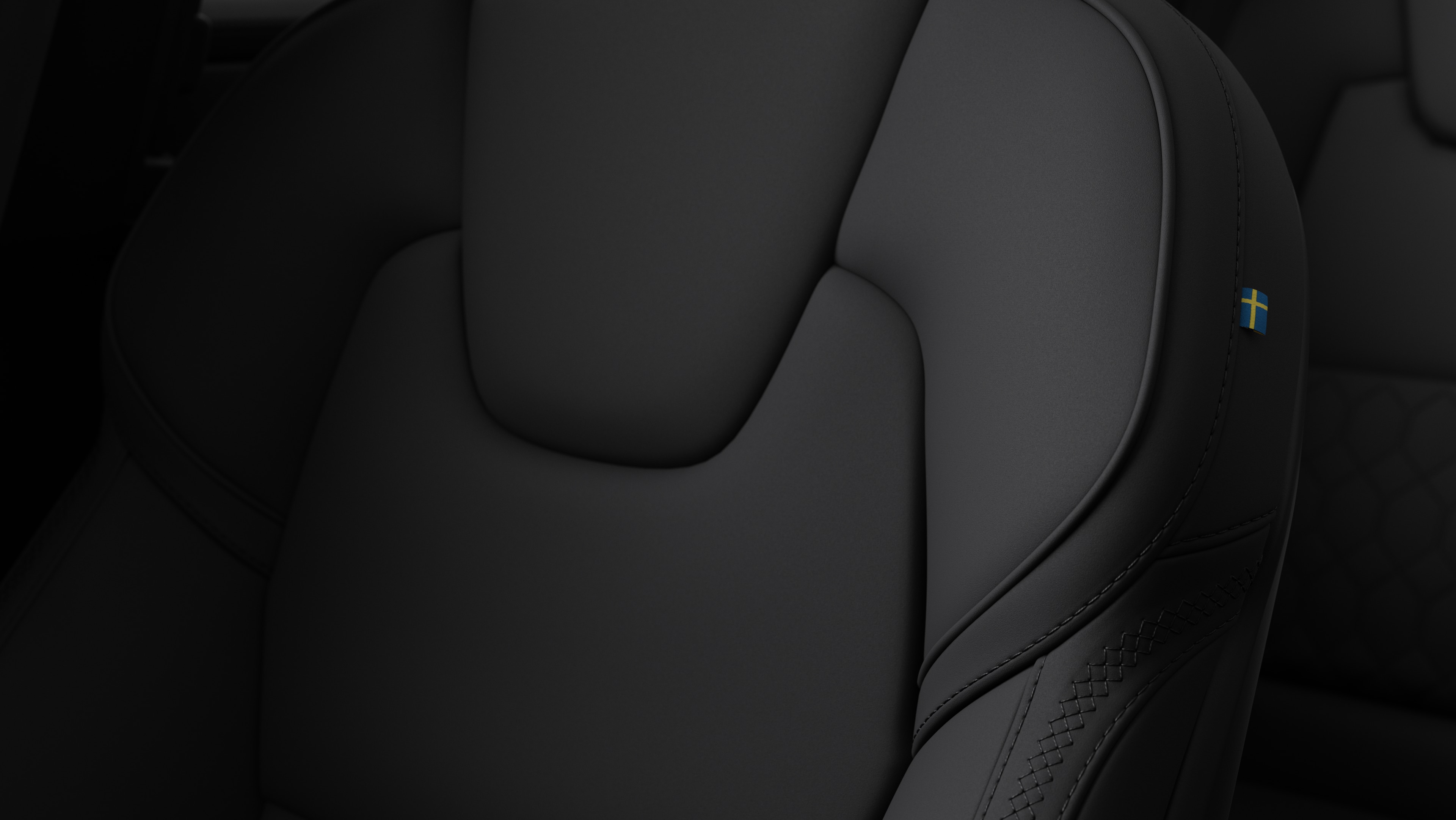 스티칭과 작은 스웨덴 국기 태그를 보여주는 볼보 자동차 내부 시트 디테일 클로즈업.