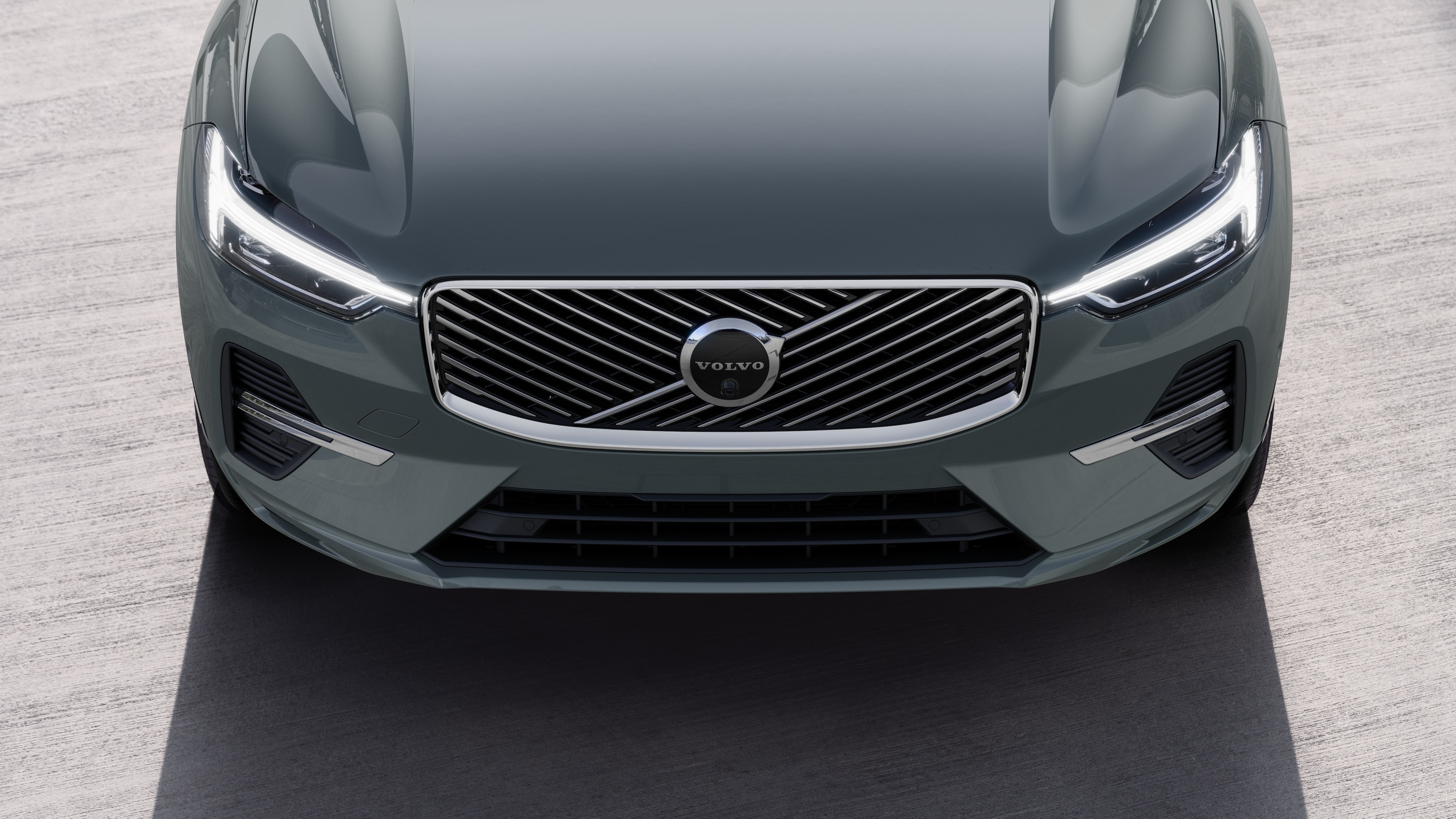 Volvo car exterior in three-quarter view on an urban street background, showing one side, roof, and part of the front.