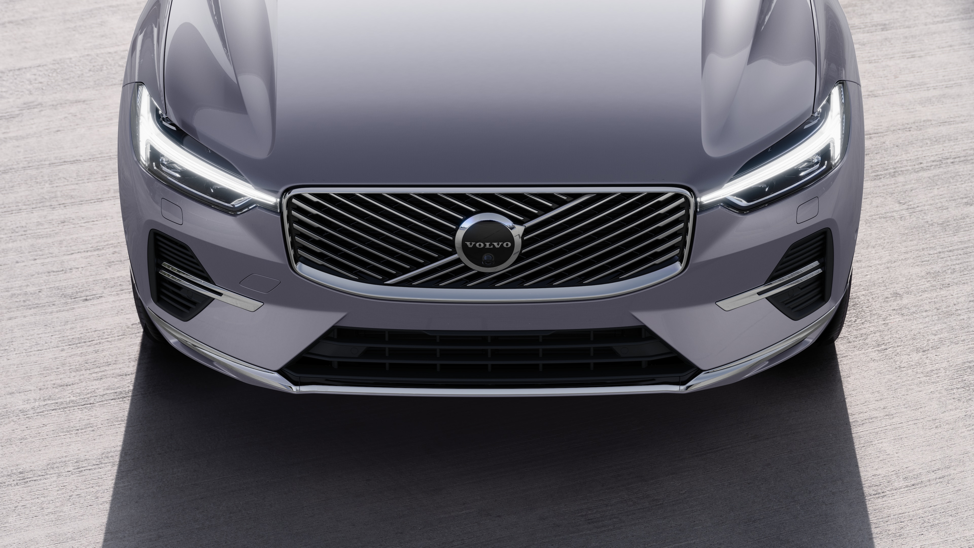 Volvo car exterior in three-quarter view on an urban street background, showing one side, roof, and part of the front.