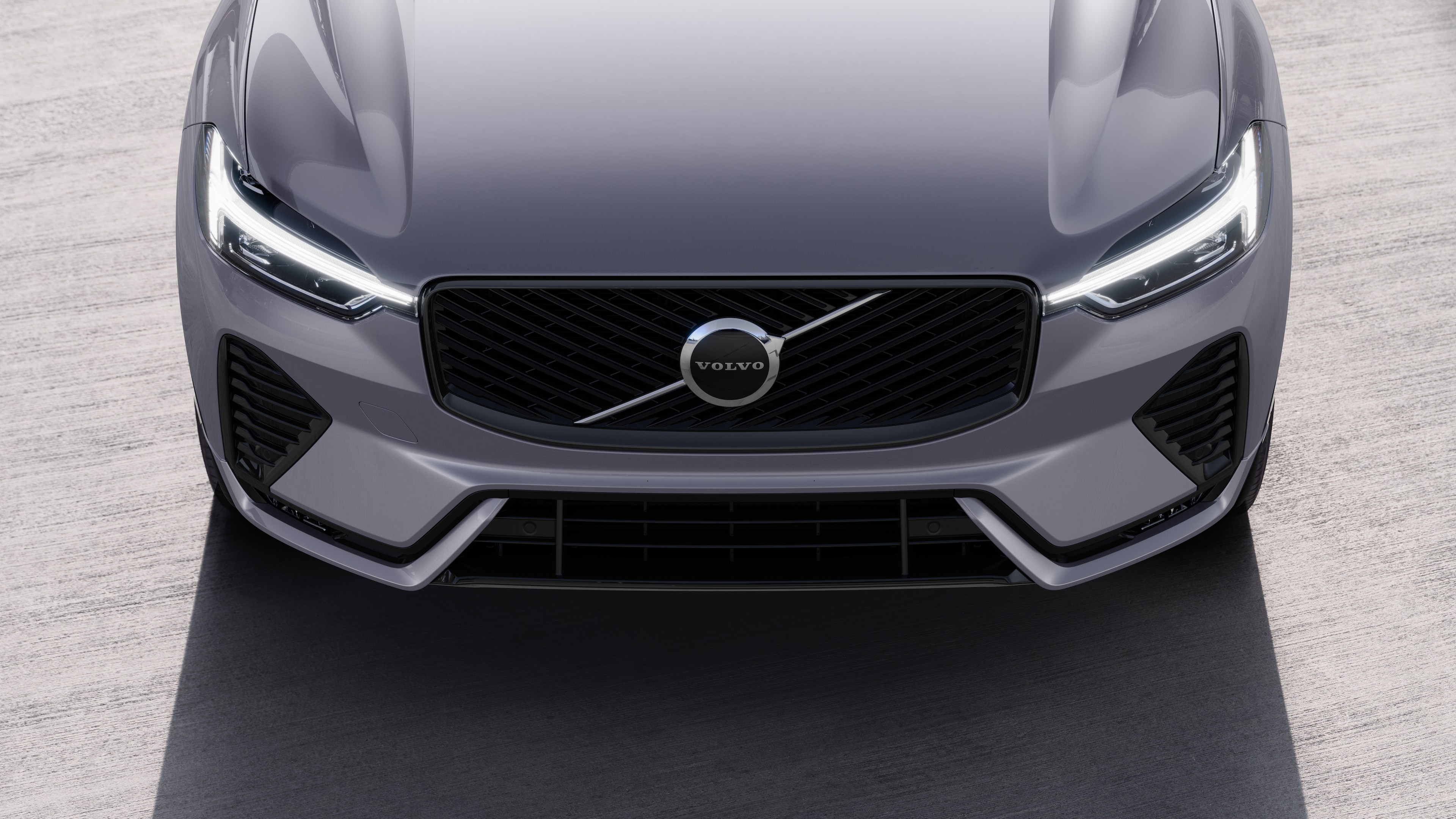 Volvo car exterior in three-quarter view on an urban street background, showing one side, roof, and part of the front.