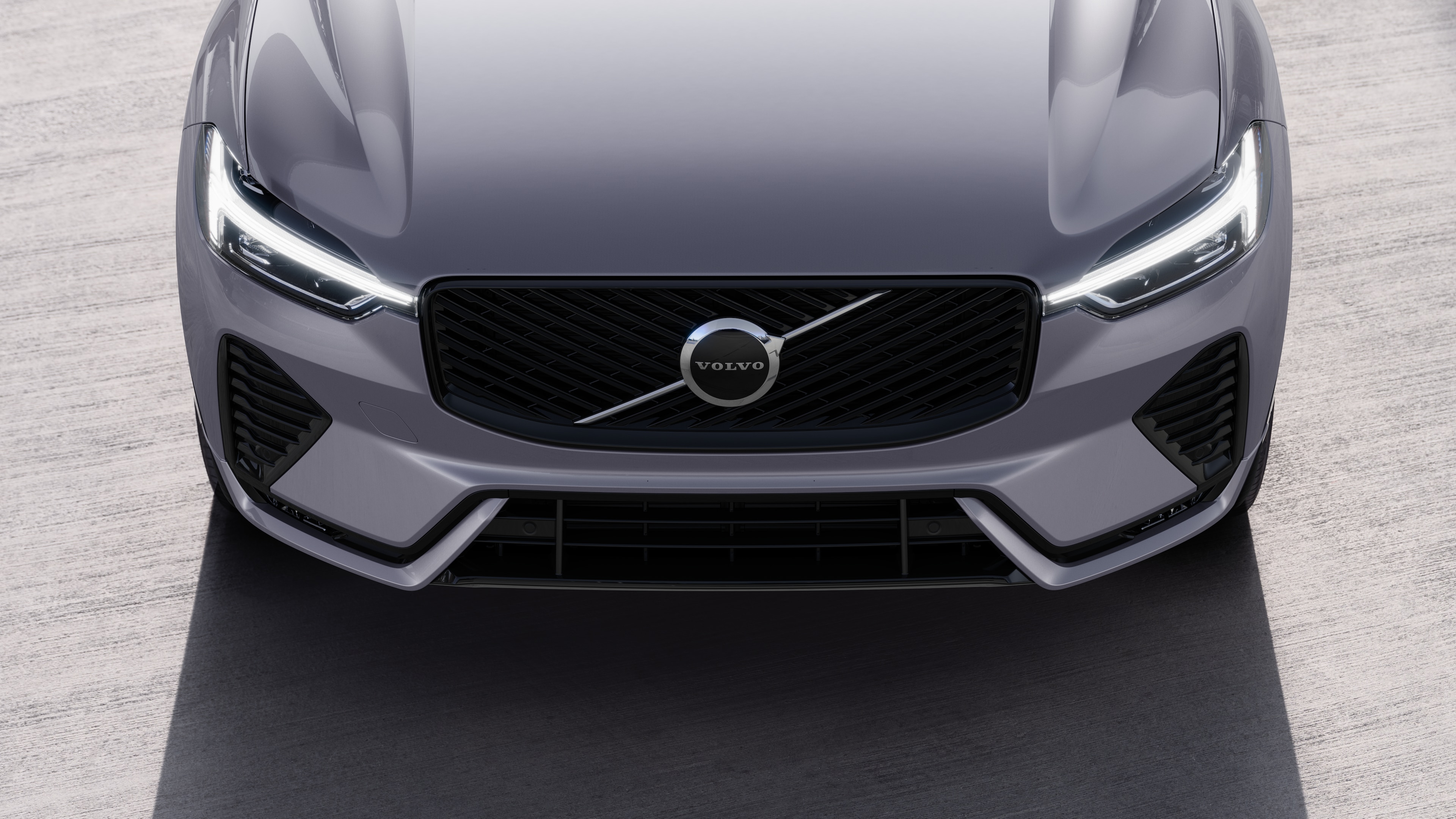 L’extérieur d’une voiture Volvo vue de trois quarts sur un arrière-plan de rue urbaine, montrant un côté, le toit et une partie de l’avant.