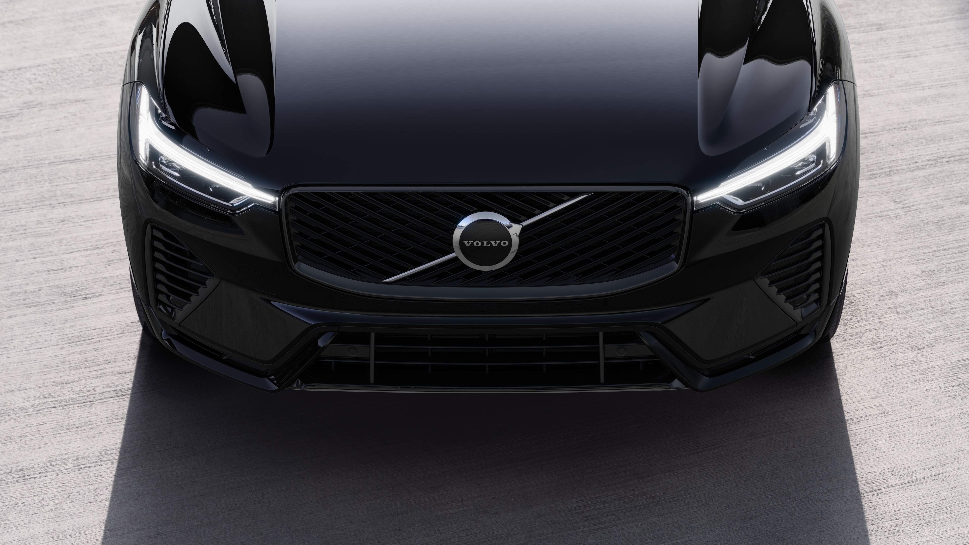 Volvo car exterior in three-quarter view on an urban street background, showing one side, roof, and part of the front.