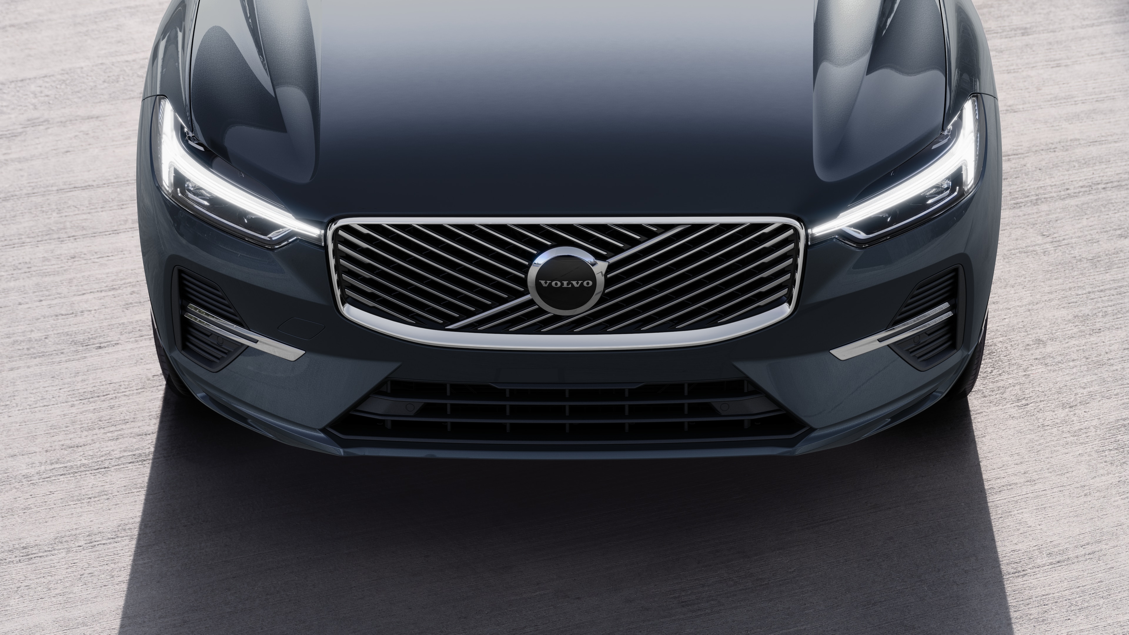 Volvo car exterior in three-quarter view on an urban street background, showing one side, roof, and part of the front.