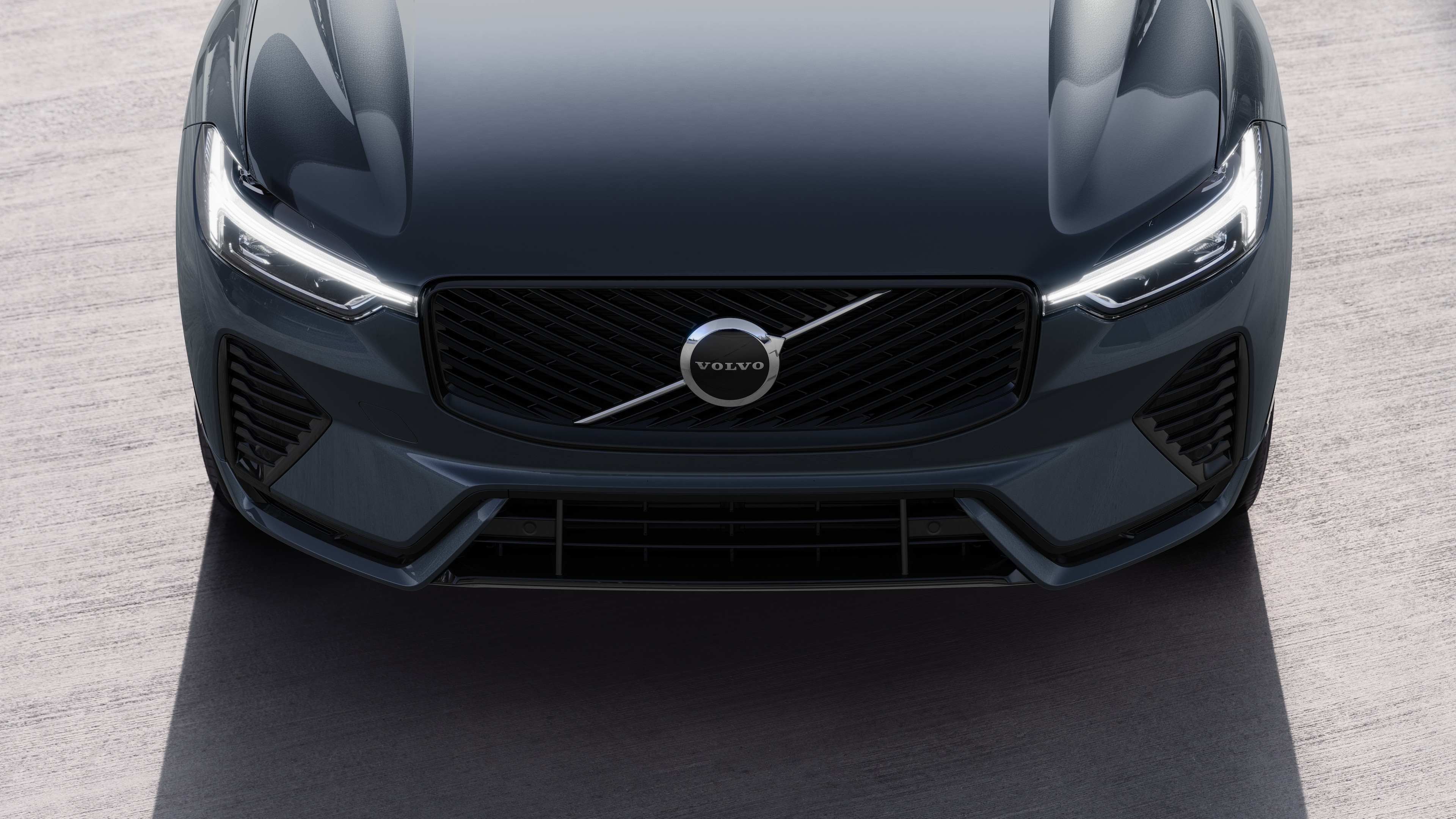 Volvo automašīnas ārpuse trīs ceturtdaļu skatā uz pilsētas ielas fona, parādot vienu pusi, jumtu un daļu priekšpuses.