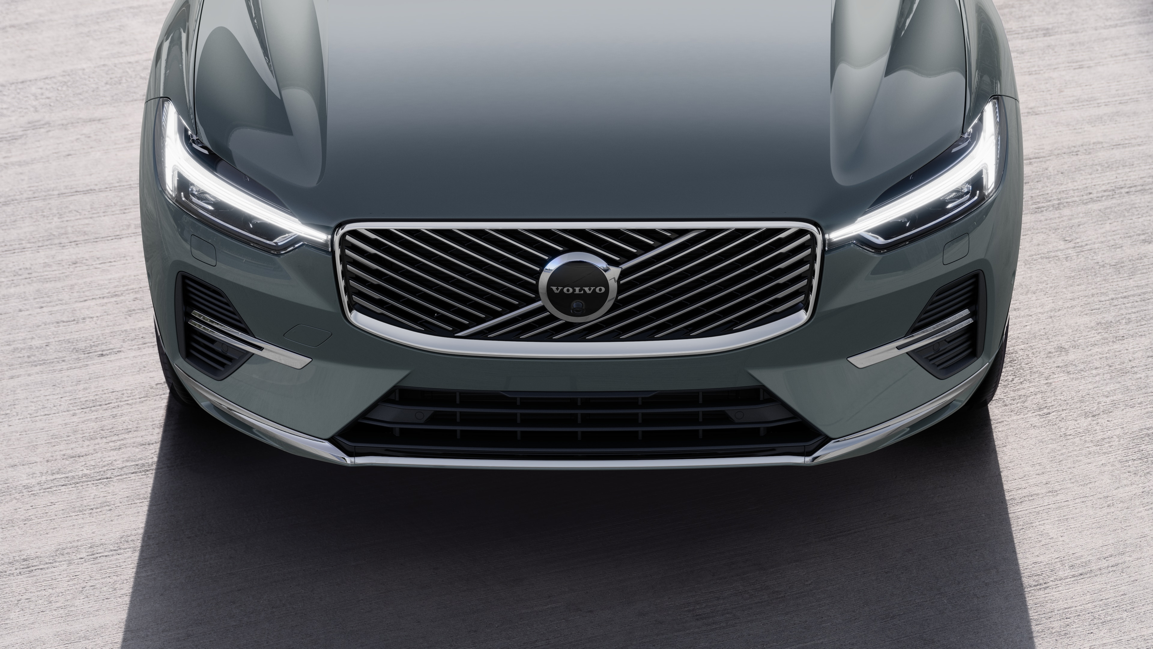 Volvo-bíll að utan í þriggja fjórðu hluta götubakgrunns í þéttbýli sem sýnir aðra hliðina, þakið og hluta framhliðarinnar.