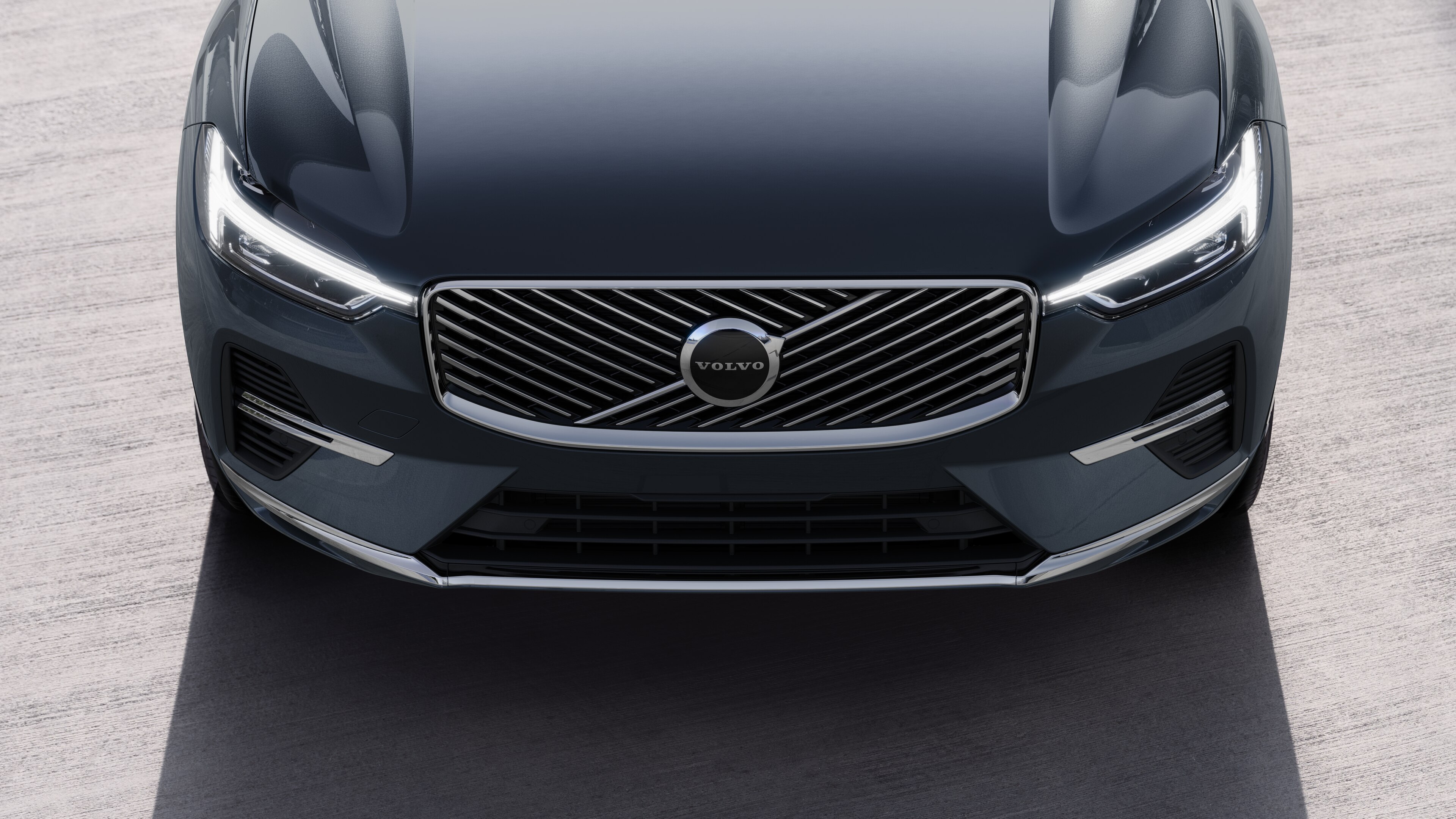 Το εξωτερικό ενός αυτοκινήτου Volvo σε άποψη τριών τετάρτων σε αστικό φόντο, όπου φαίνεται η μία πλευρά, η οροφή και μέρος του εμπρός.