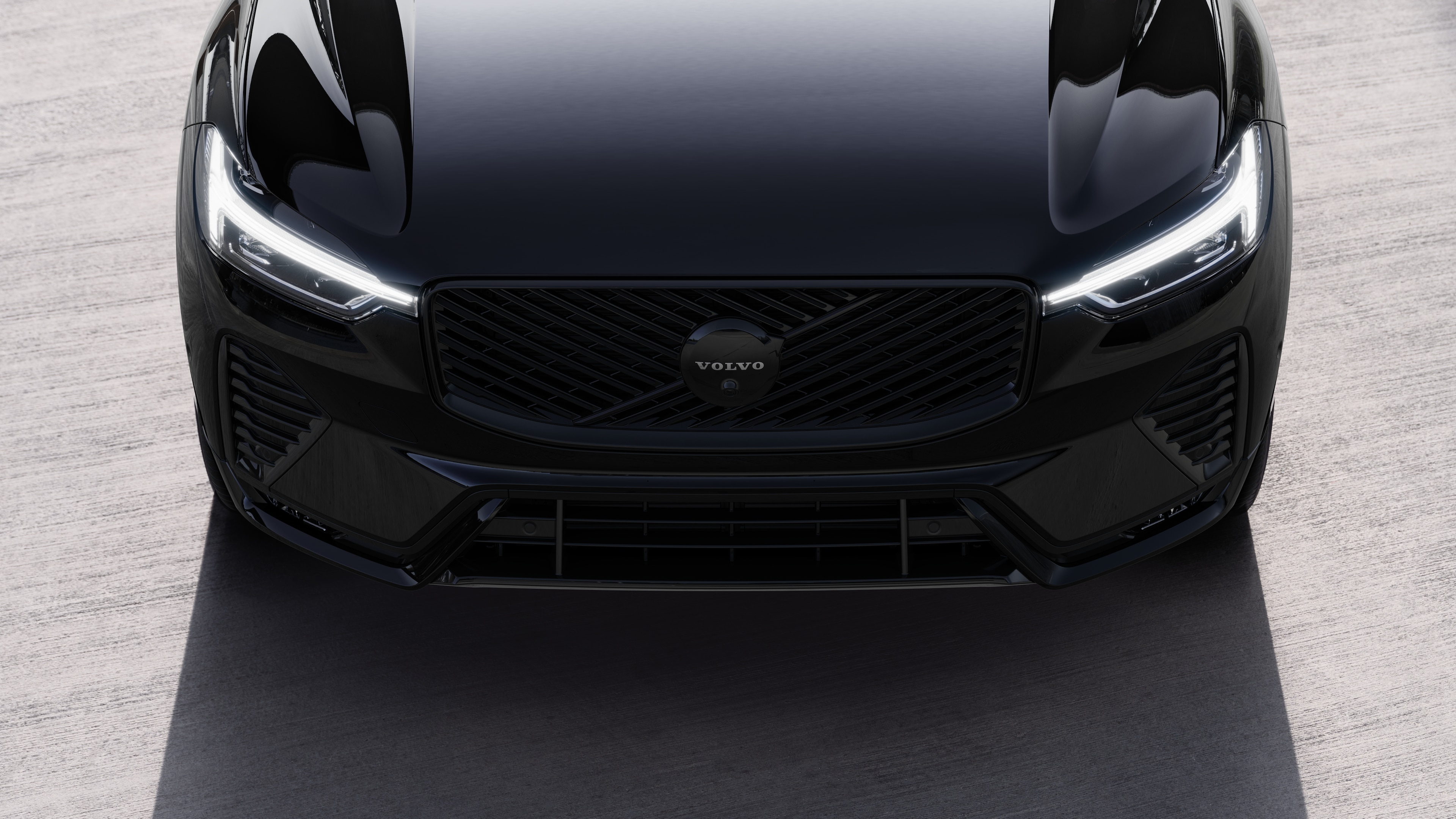 Volvo car exterior in three-quarter view on an urban street background, showing one side, roof, and part of the front.