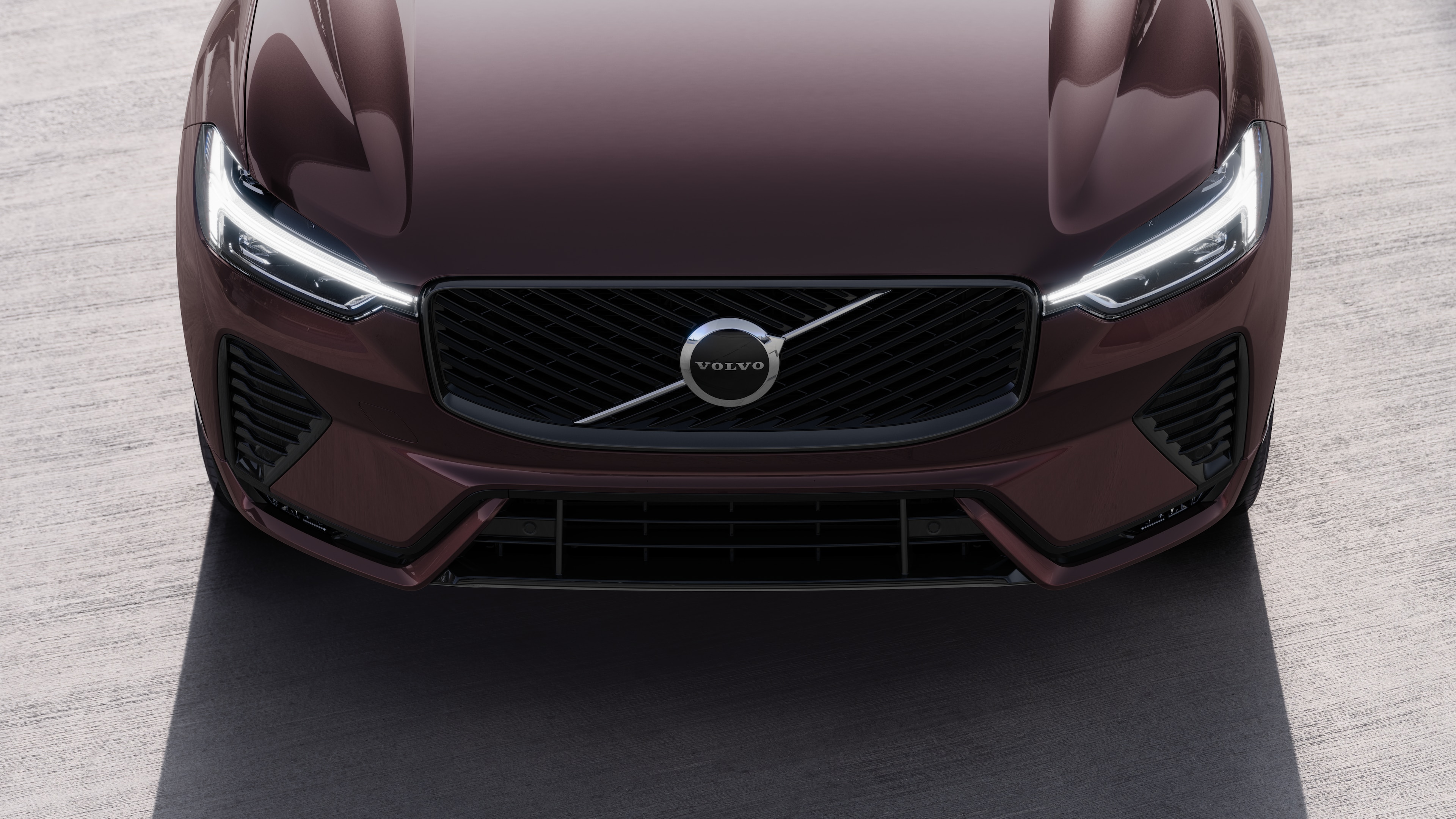 Volvo car exterior in three-quarter view on an urban street background, showing one side, roof, and part of the front.