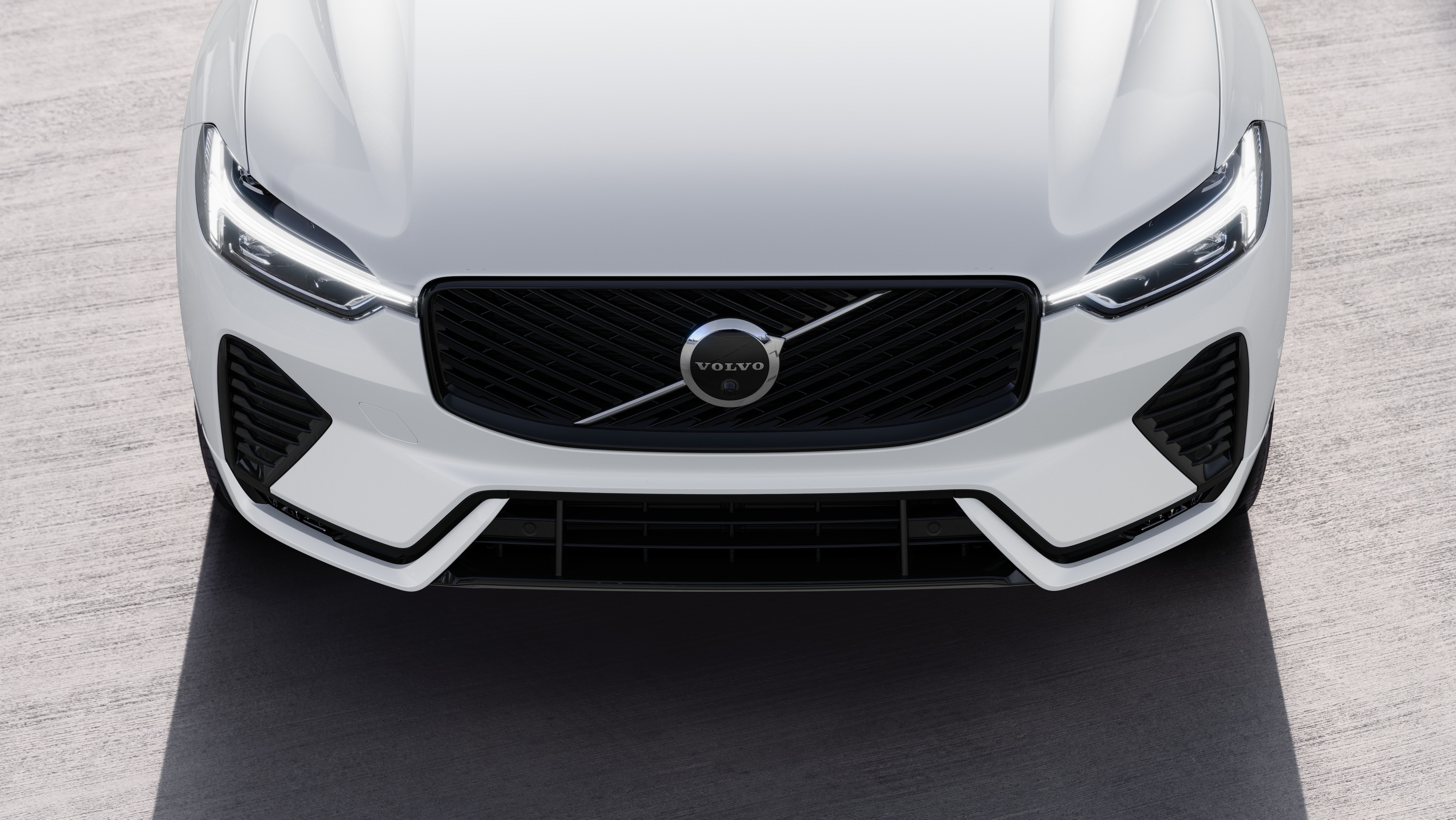 Volvo car exterior in three-quarter view on an urban street background, showing one side, roof, and part of the front.