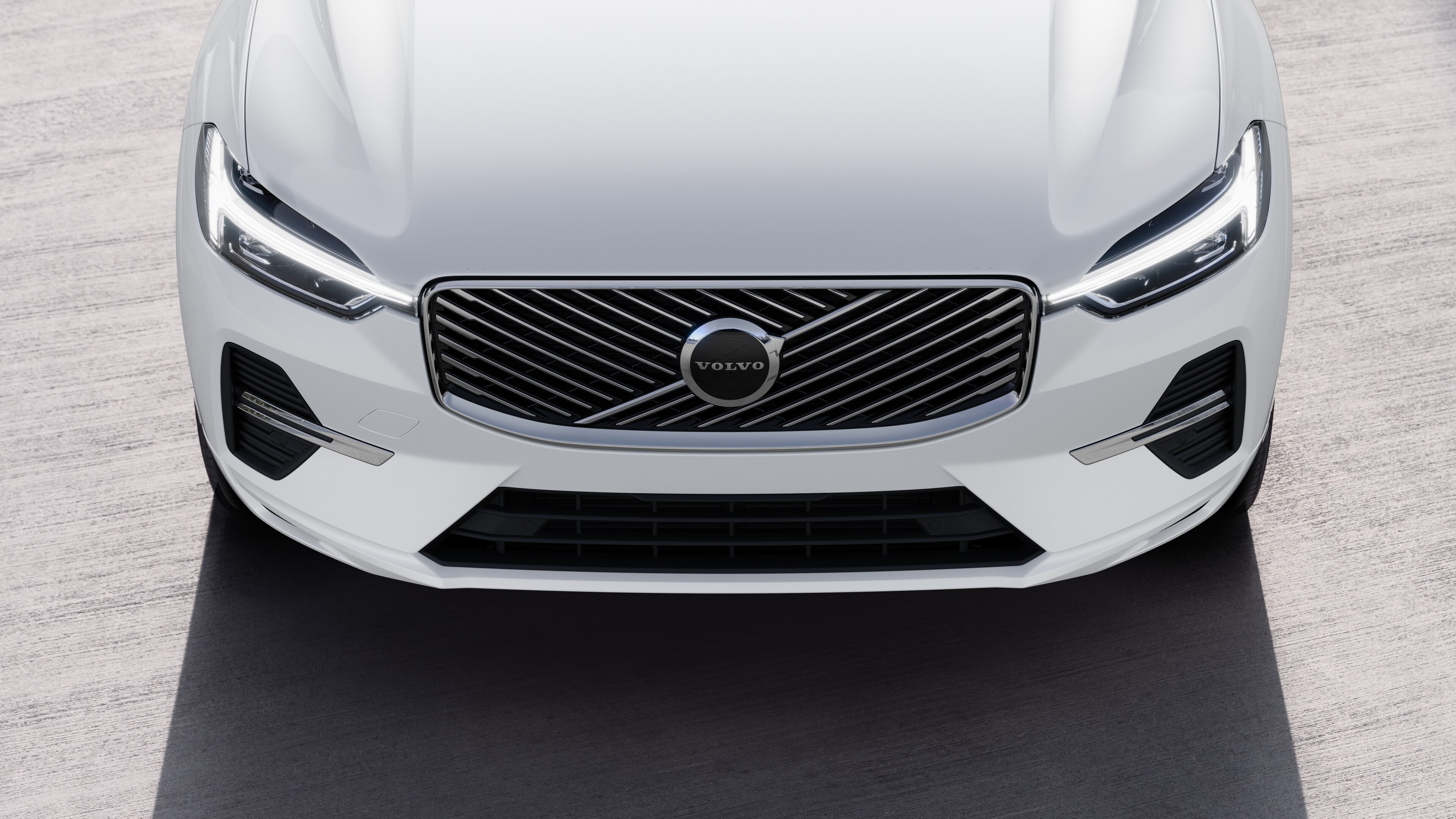 Volvo car exterior in three-quarter view on an urban street background, showing one side, roof, and part of the front.