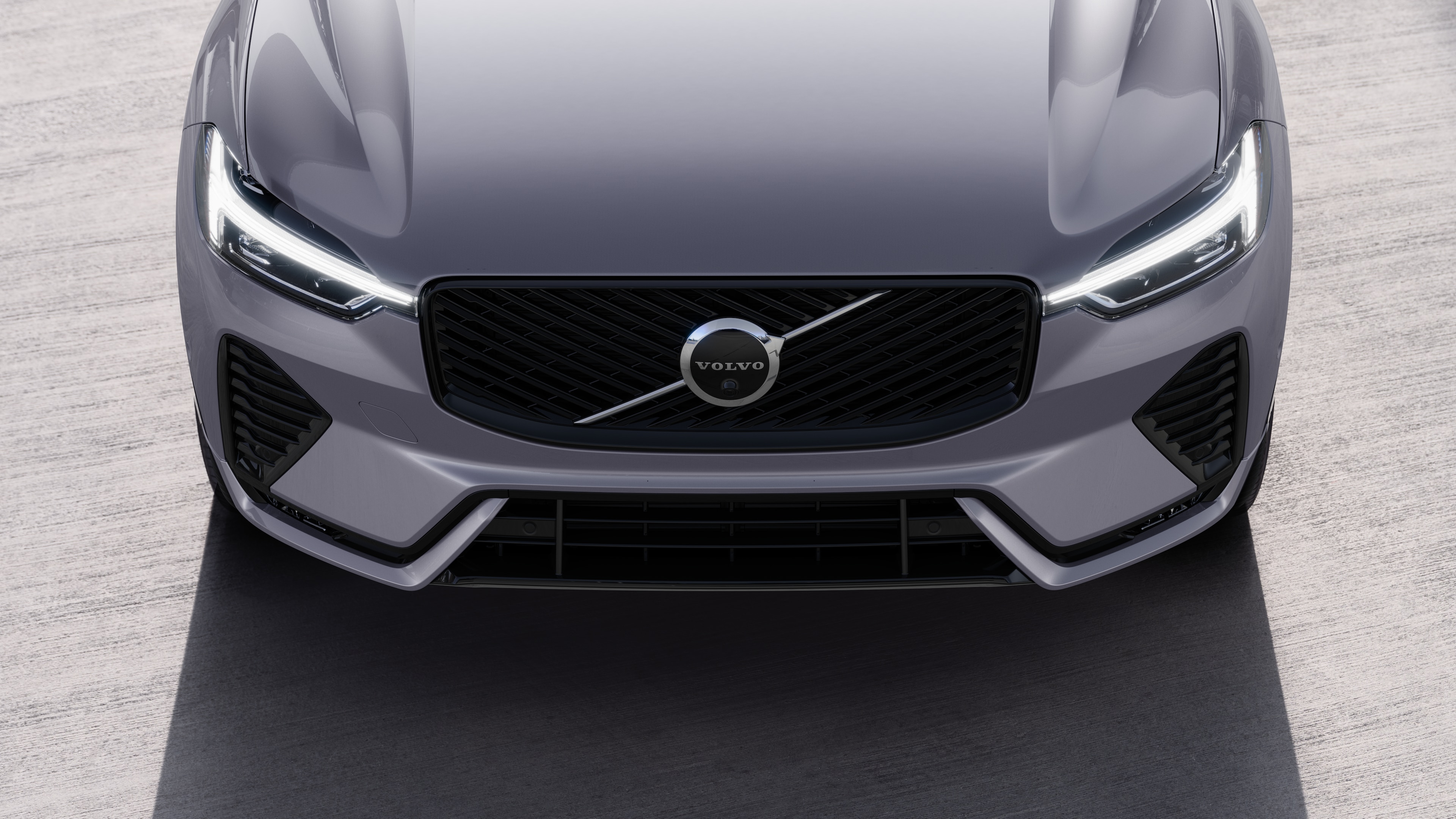 Volvo car exterior in three-quarter view on an urban street background, showing one side, roof, and part of the front.