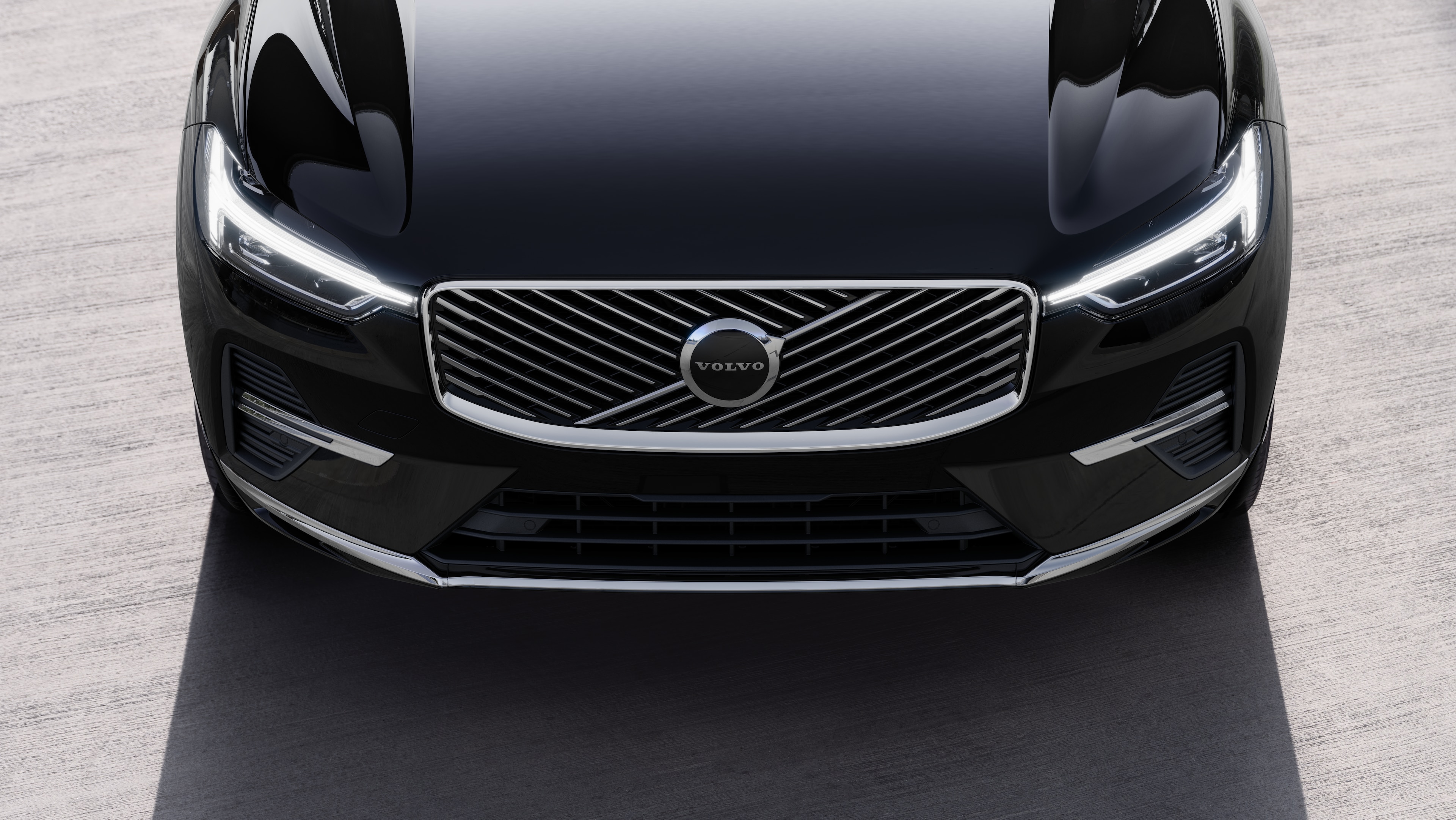 Volvo car exterior in three-quarter view on an urban street background, showing one side, roof, and part of the front.