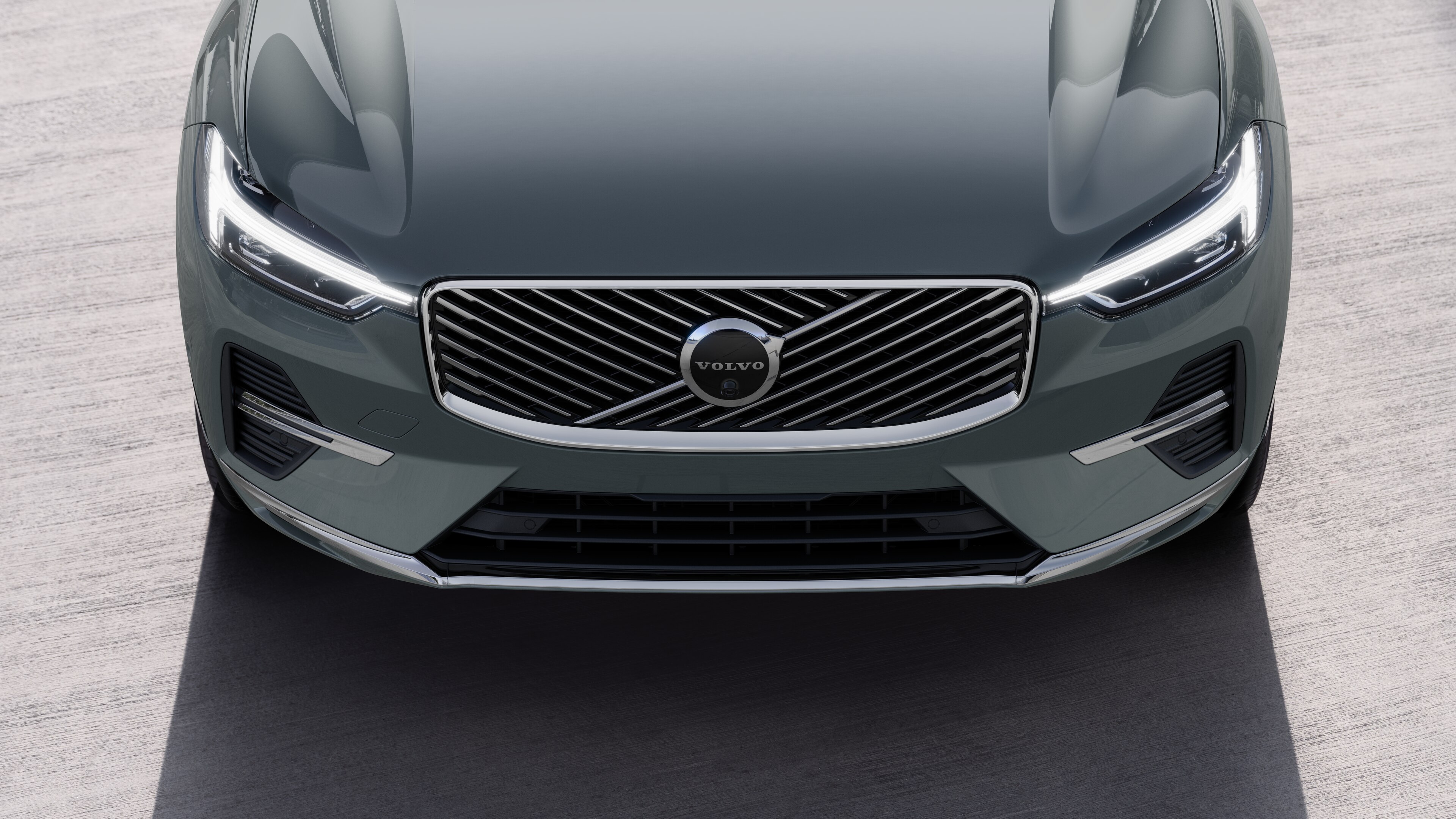 Volvo car exterior in three-quarter view on an urban street background, showing one side, roof, and part of the front.