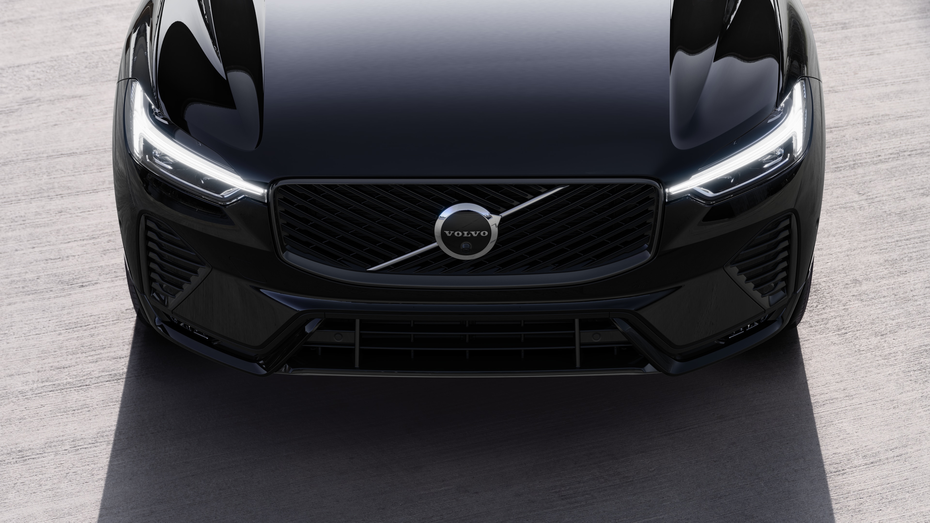 Volvo car exterior in three-quarter view on an urban street background, showing one side, roof, and part of the front.