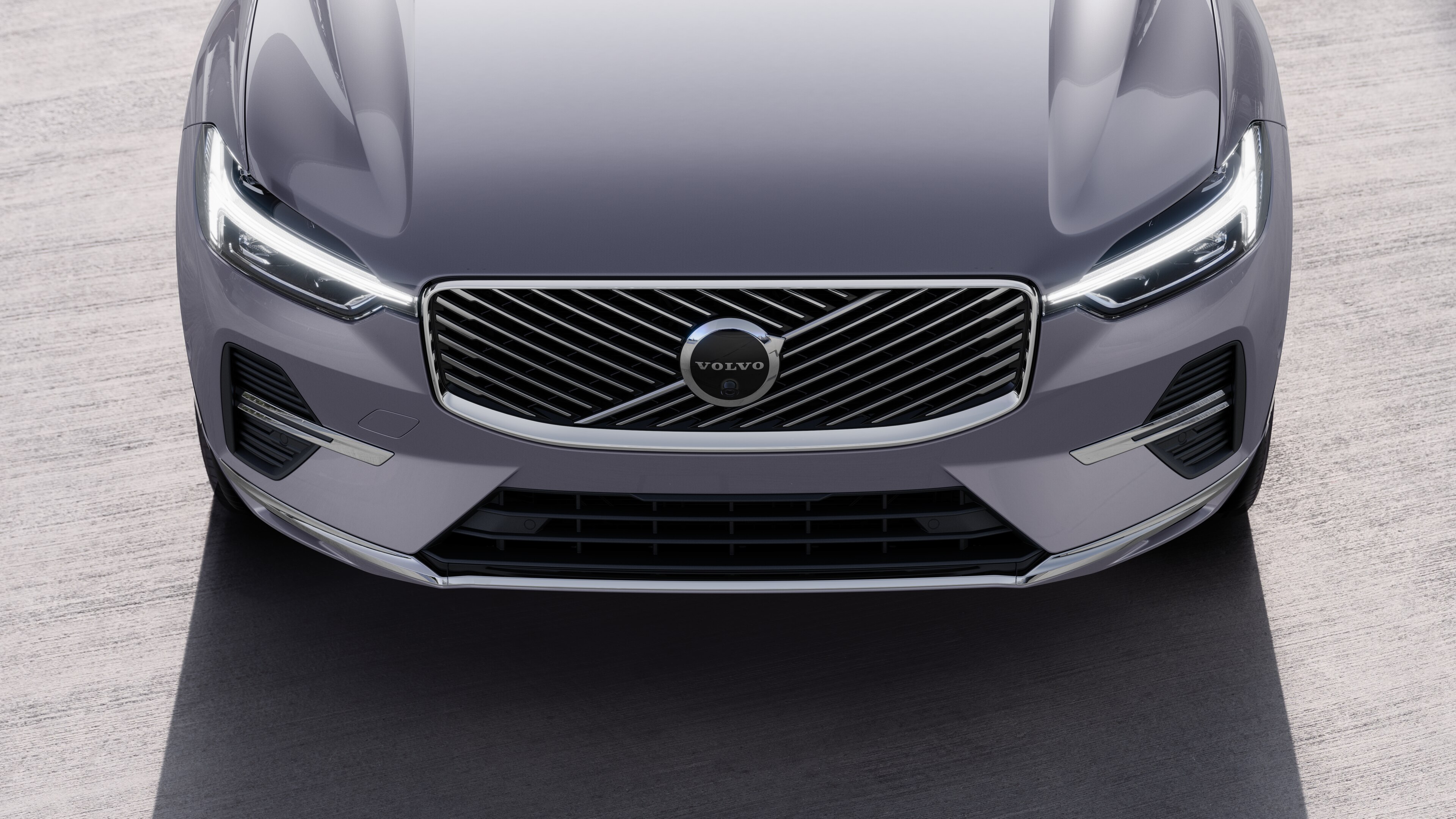 Volvo car exterior in three-quarter view on an urban street background, showing one side, roof, and part of the front.