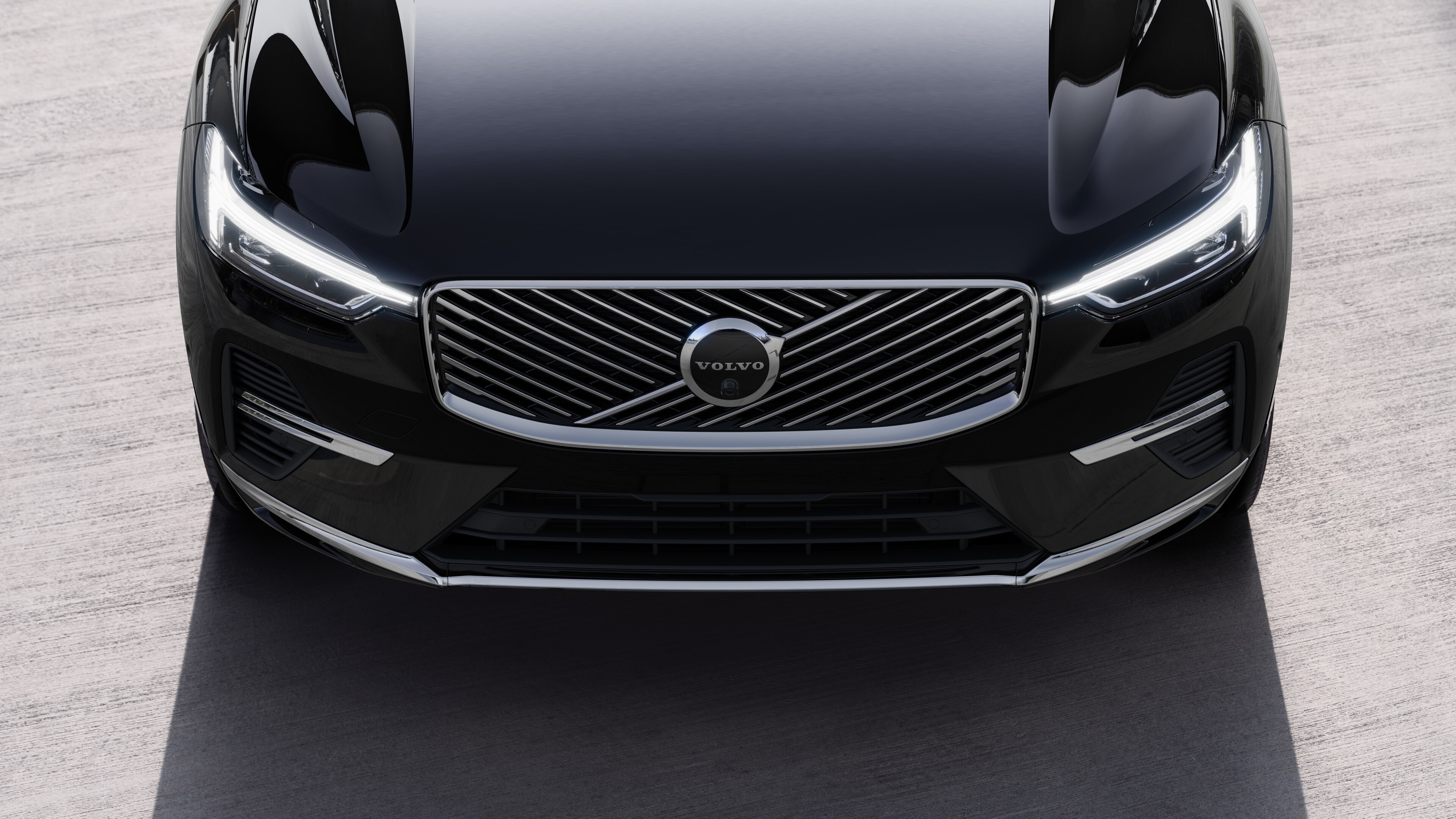 منظر خارجي لسيارة فولفو من ثلاثة أرباع سيارة فولفو على خلفية شارع حضري، يظهر جانبا واحدا وسقفا وجزءا من المقدمة.