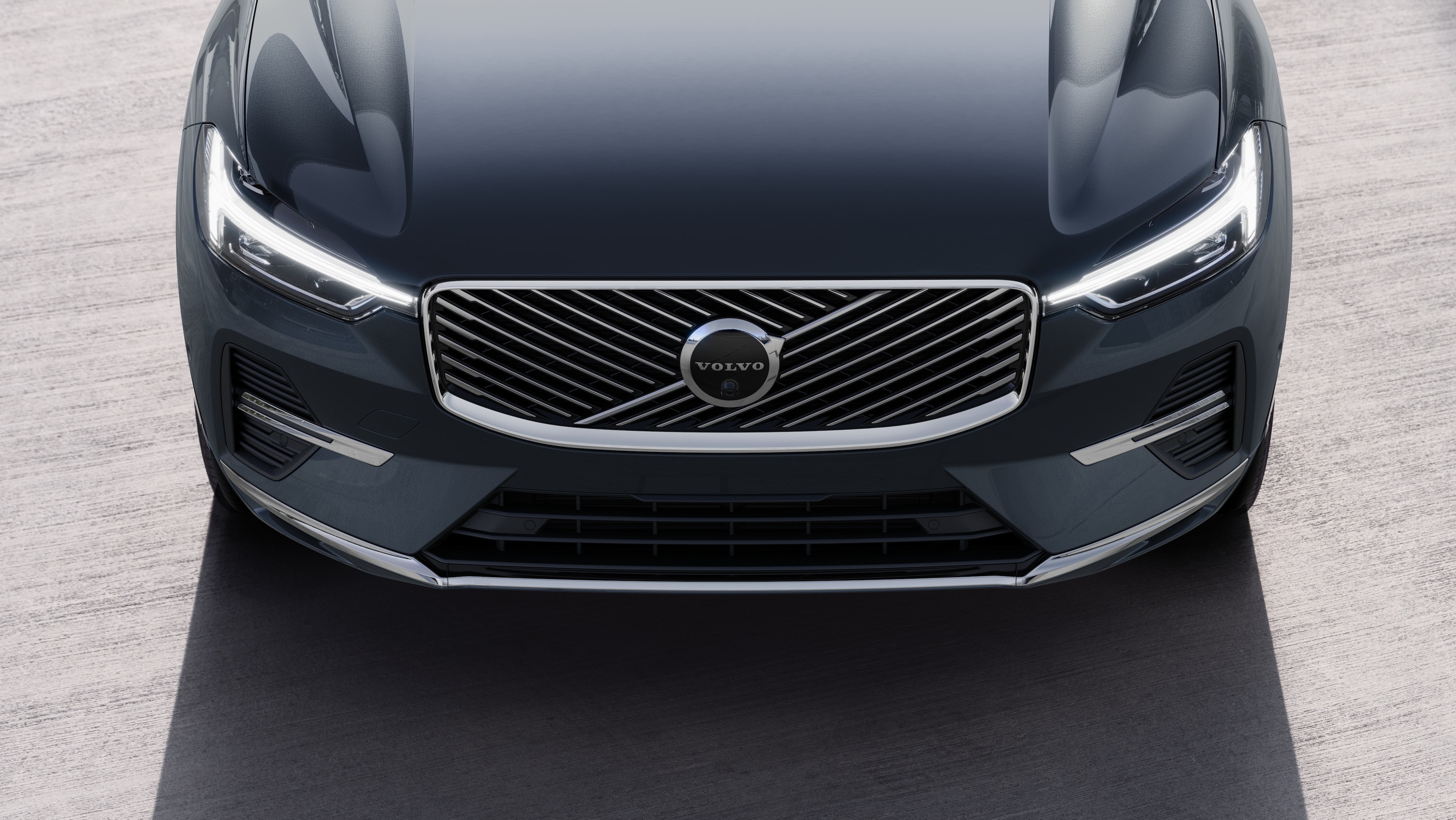 Volvo car exterior in three-quarter view on an urban street background, showing one side, roof, and part of the front.