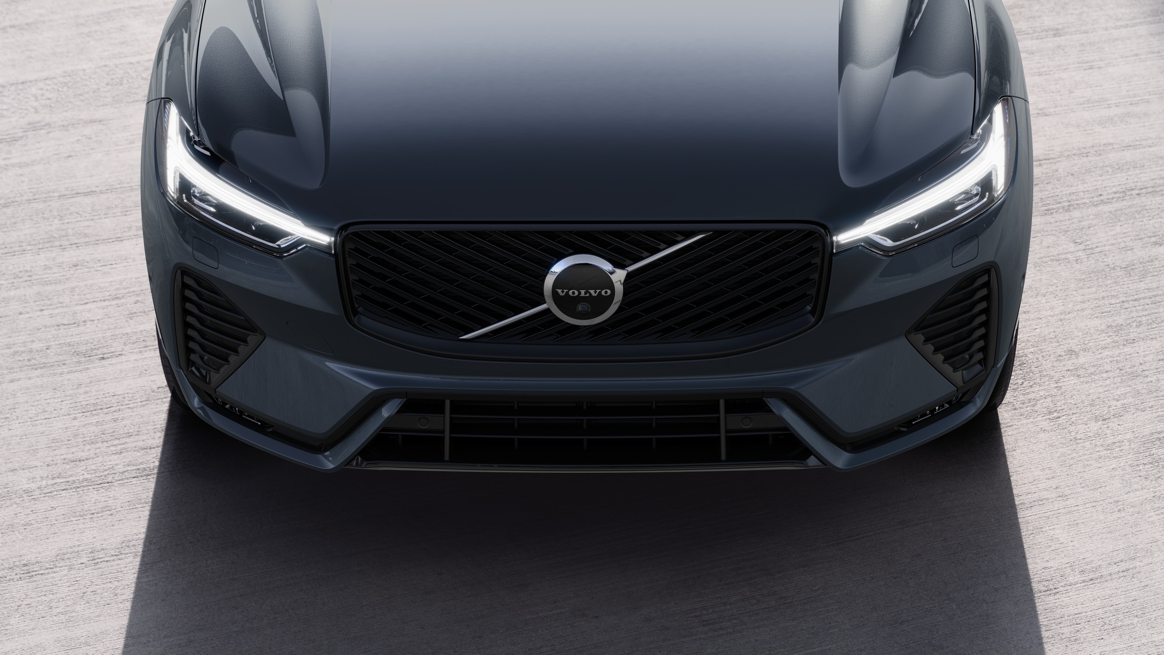 Volvo car exterior in three-quarter view on an urban street background, showing one side, roof, and part of the front.