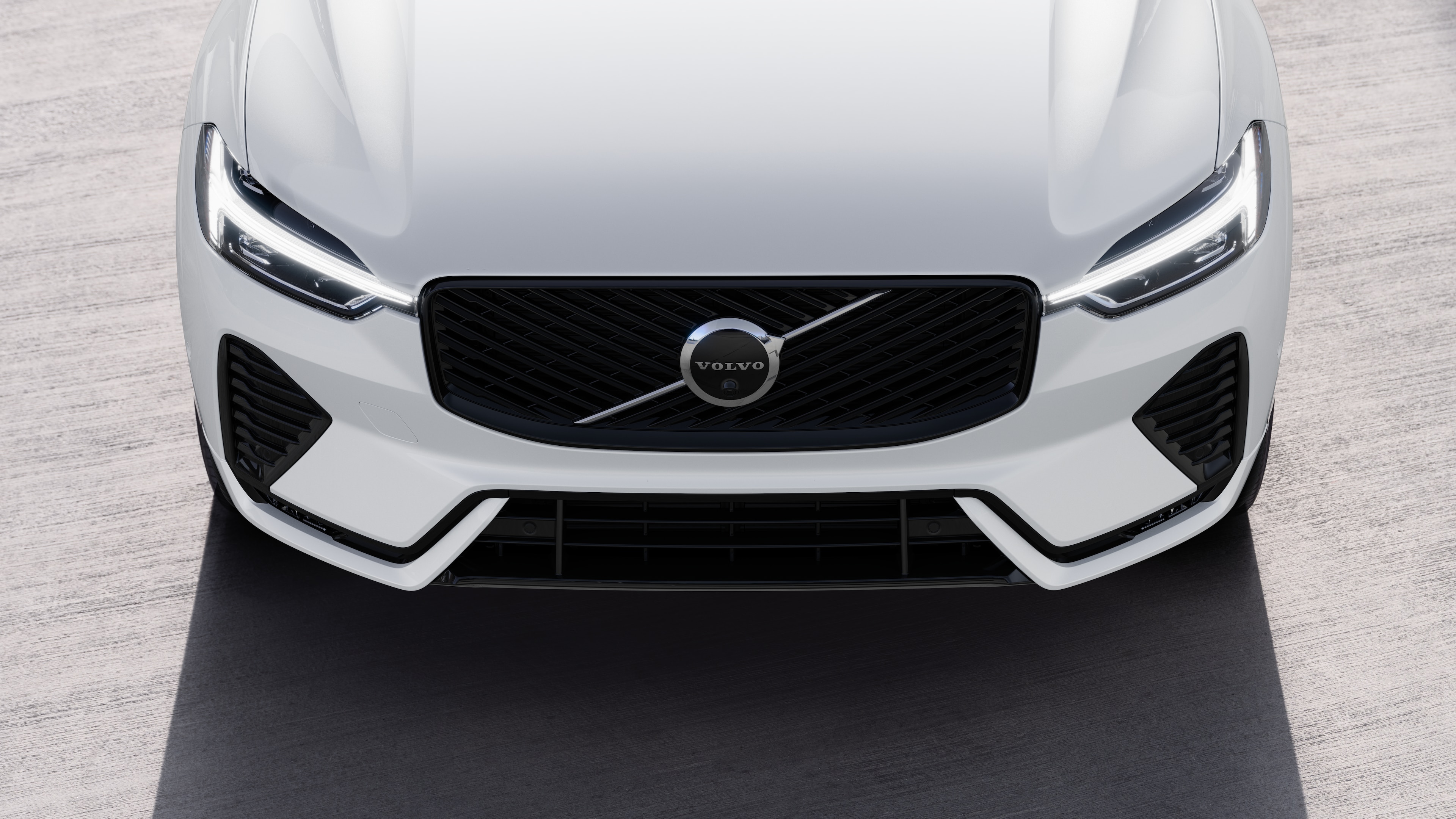 Volvo car exterior in three-quarter view on an urban street background, showing one side, roof, and part of the front.