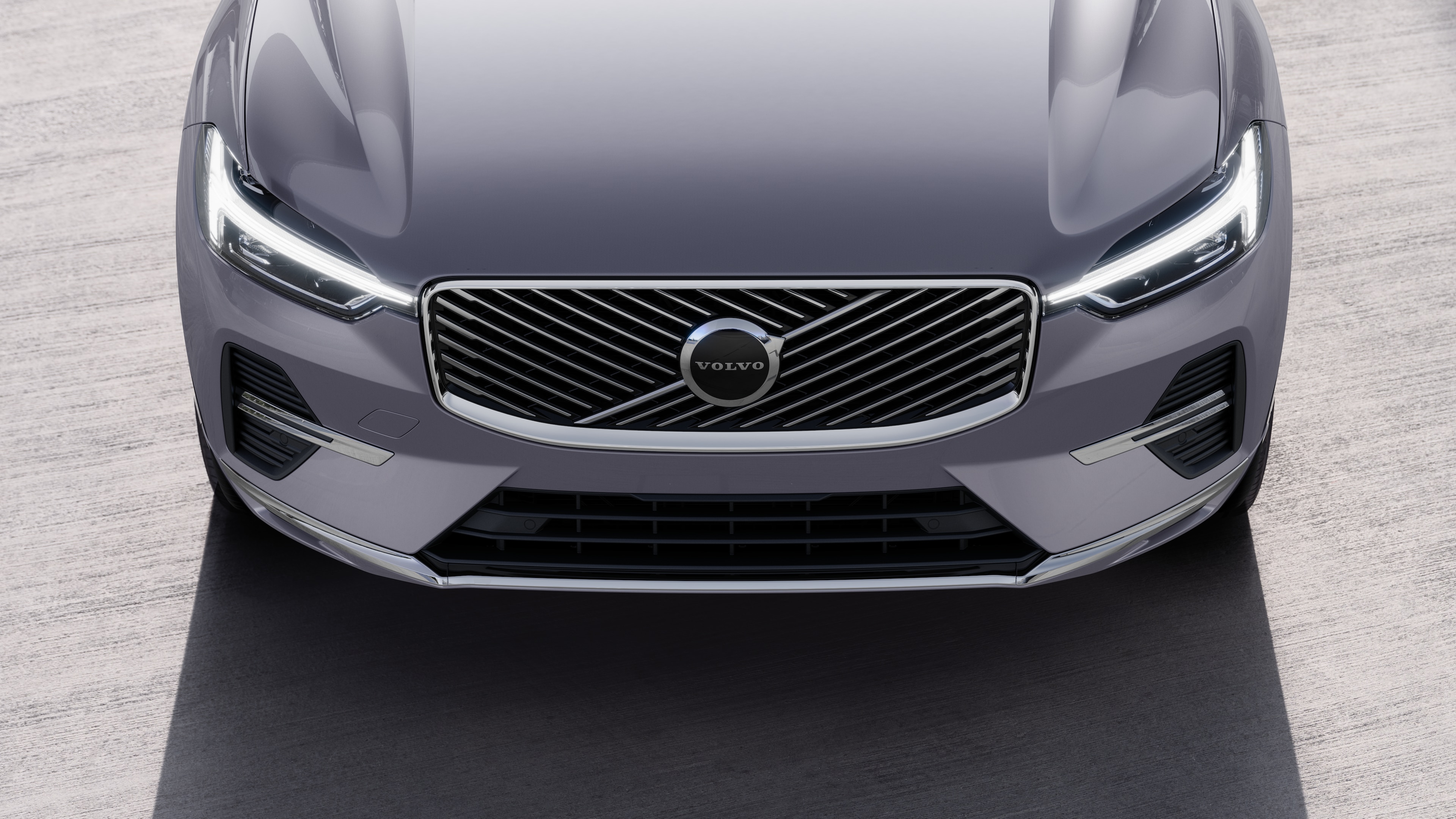 Volvo car exterior in three-quarter view on an urban street background, showing one side, roof, and part of the front.