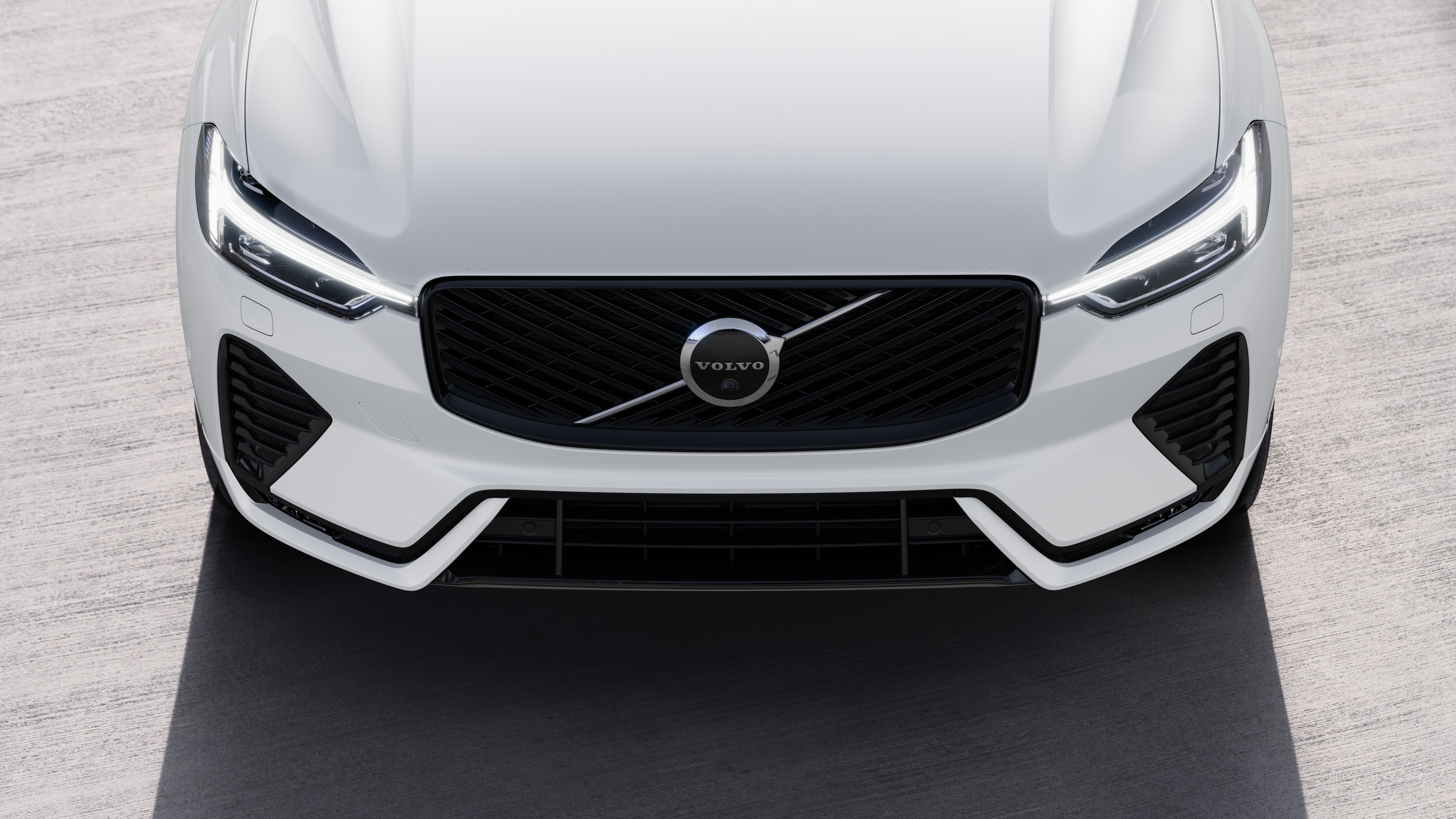 Volvo car exterior in three-quarter view on an urban street background, showing one side, roof, and part of the front.