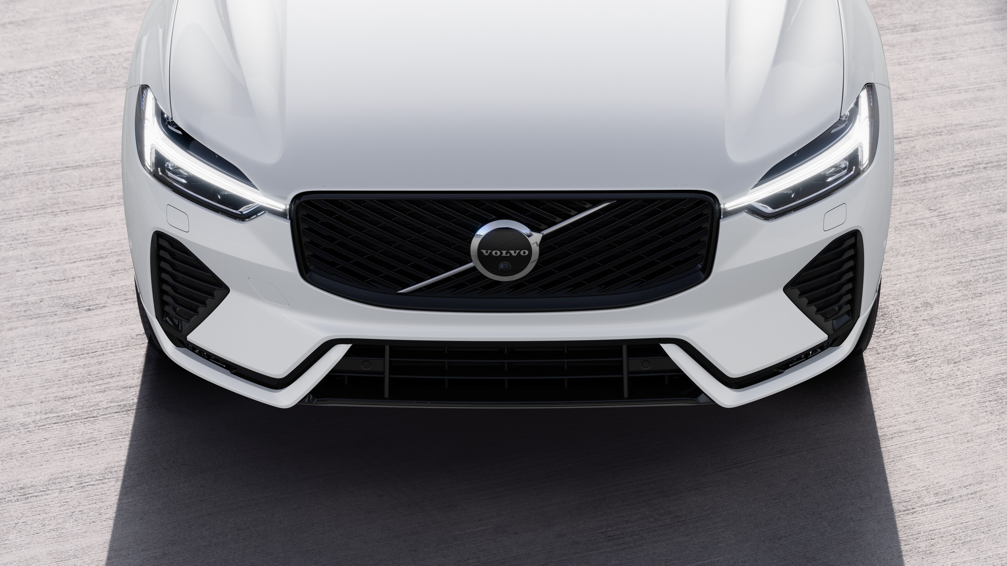 L’extérieur d’une voiture Volvo vue de trois quarts sur un arrière-plan de rue urbaine, montrant un côté, le toit et une partie de l’avant.