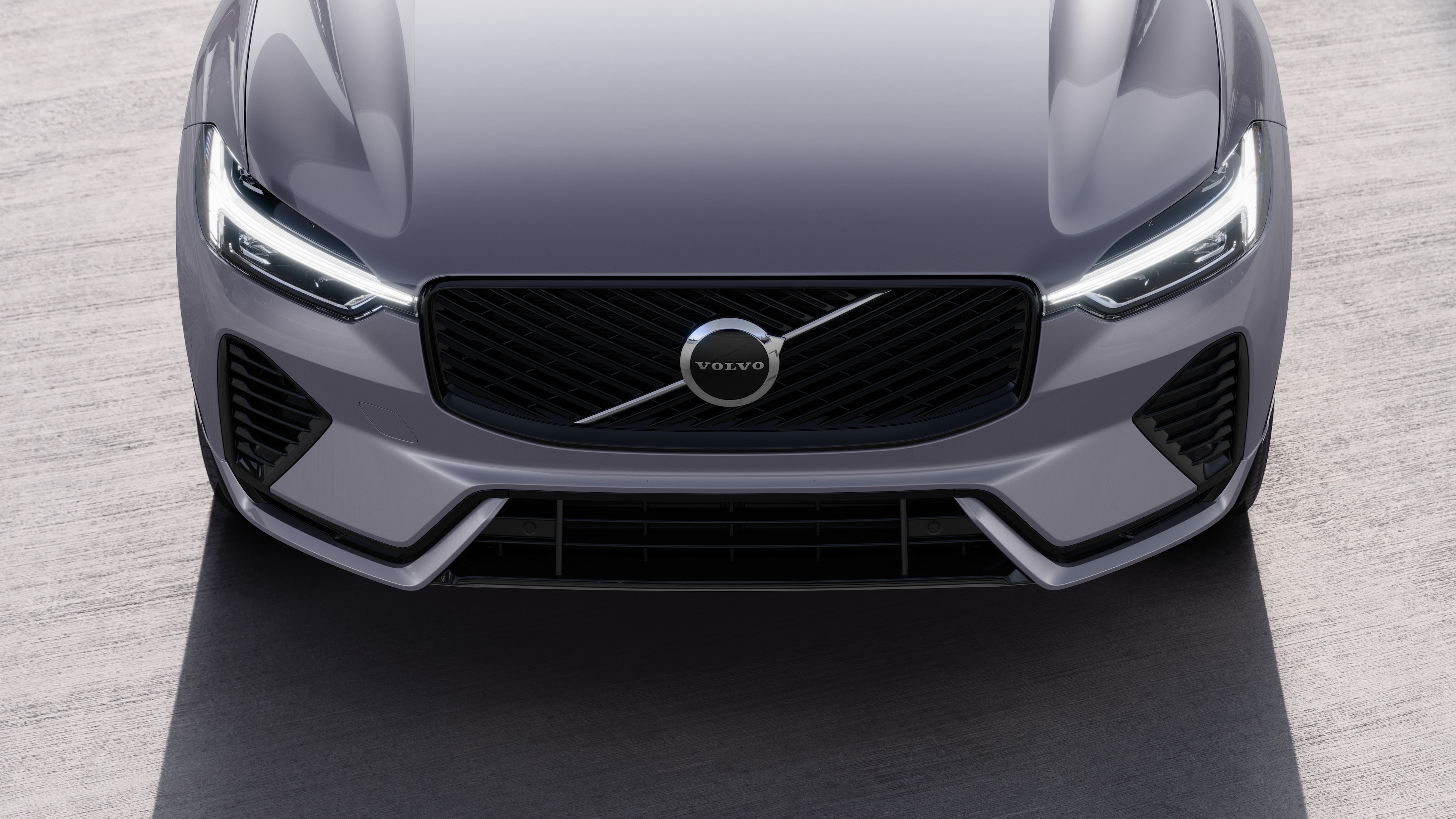 Volvo car exterior in three-quarter view on an urban street background, showing one side, roof, and part of the front.