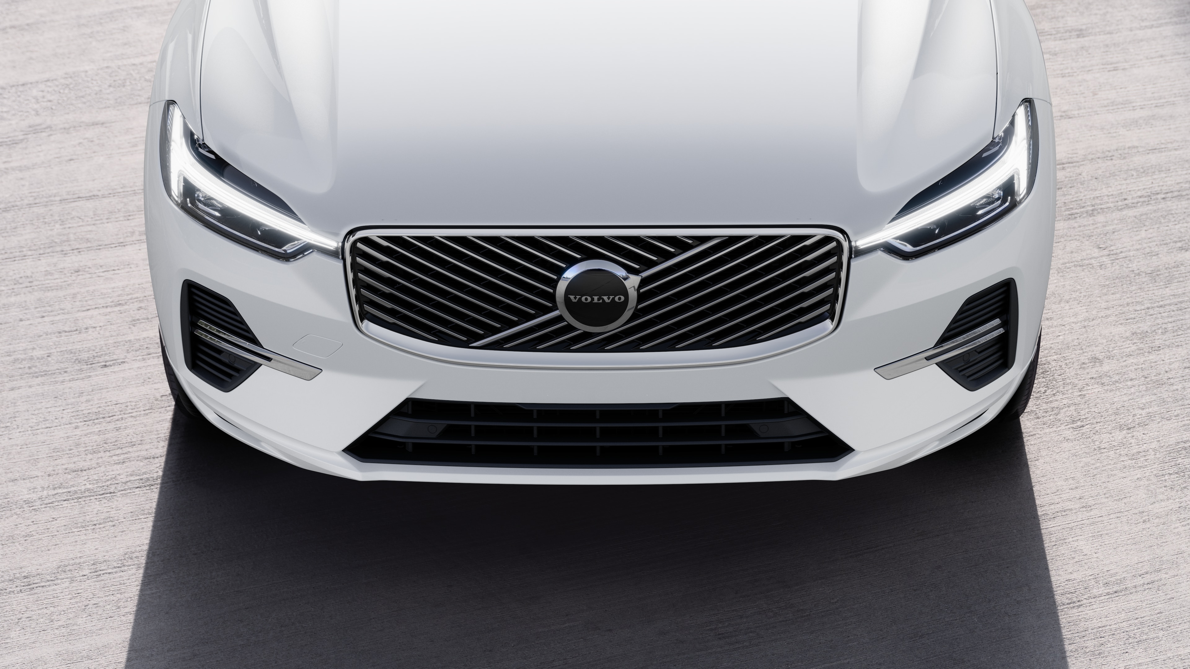 Volvo car exterior in three-quarter view on an urban street background, showing one side, roof, and part of the front.