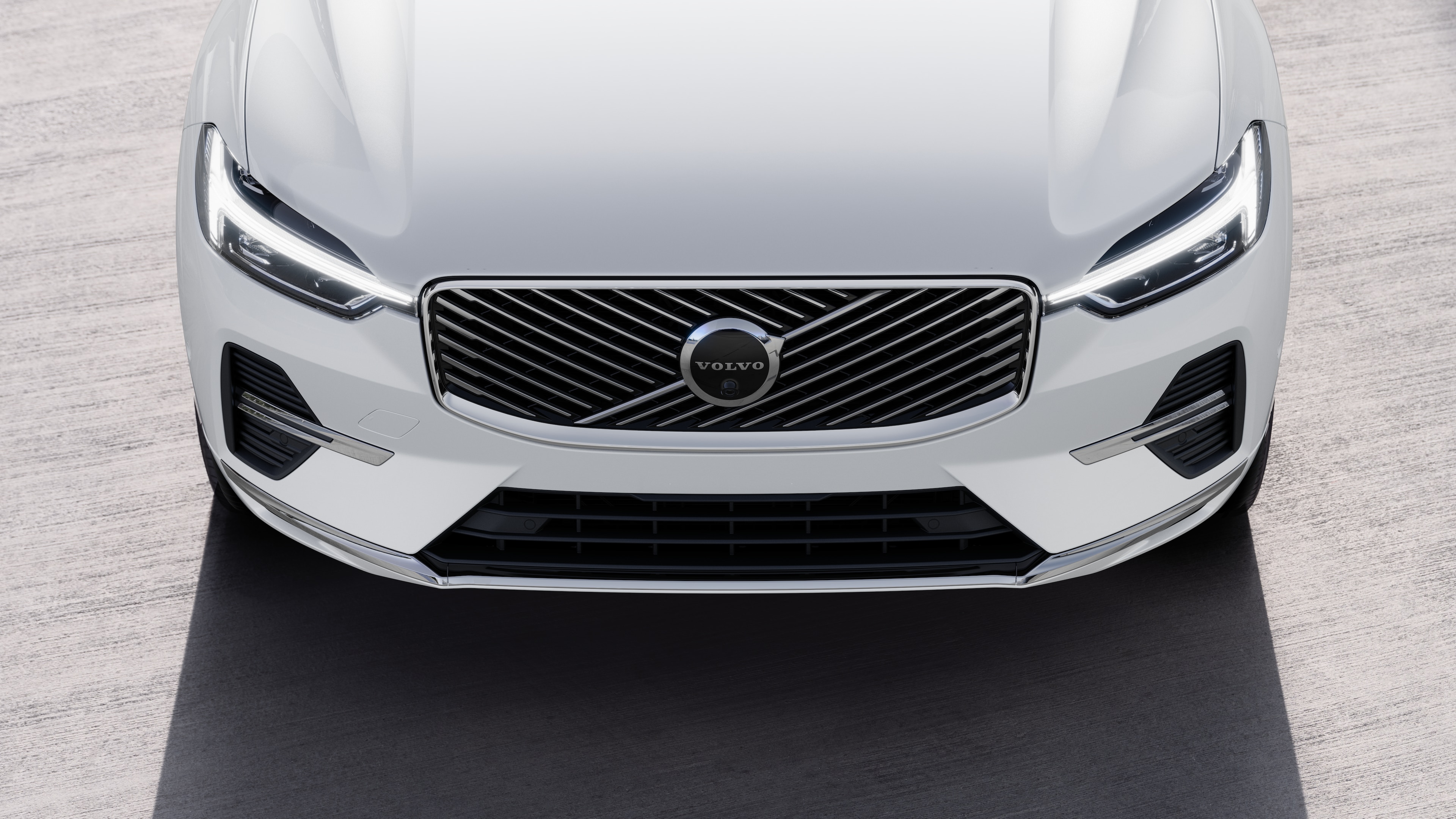 Volvo car exterior in three-quarter view on an urban street background, showing one side, roof, and part of the front.