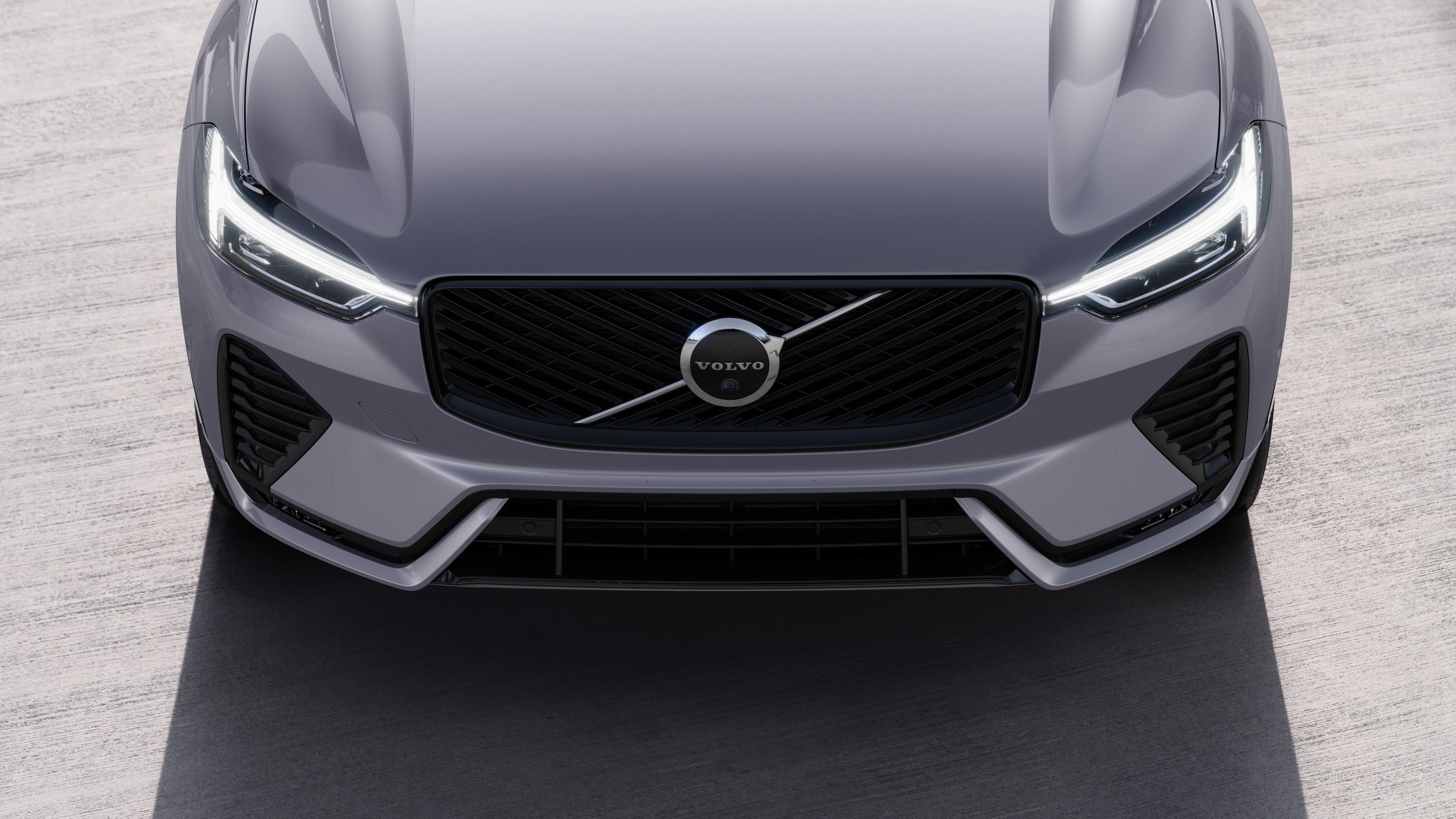 Volvo car exterior in three-quarter view on an urban street background, showing one side, roof, and part of the front.