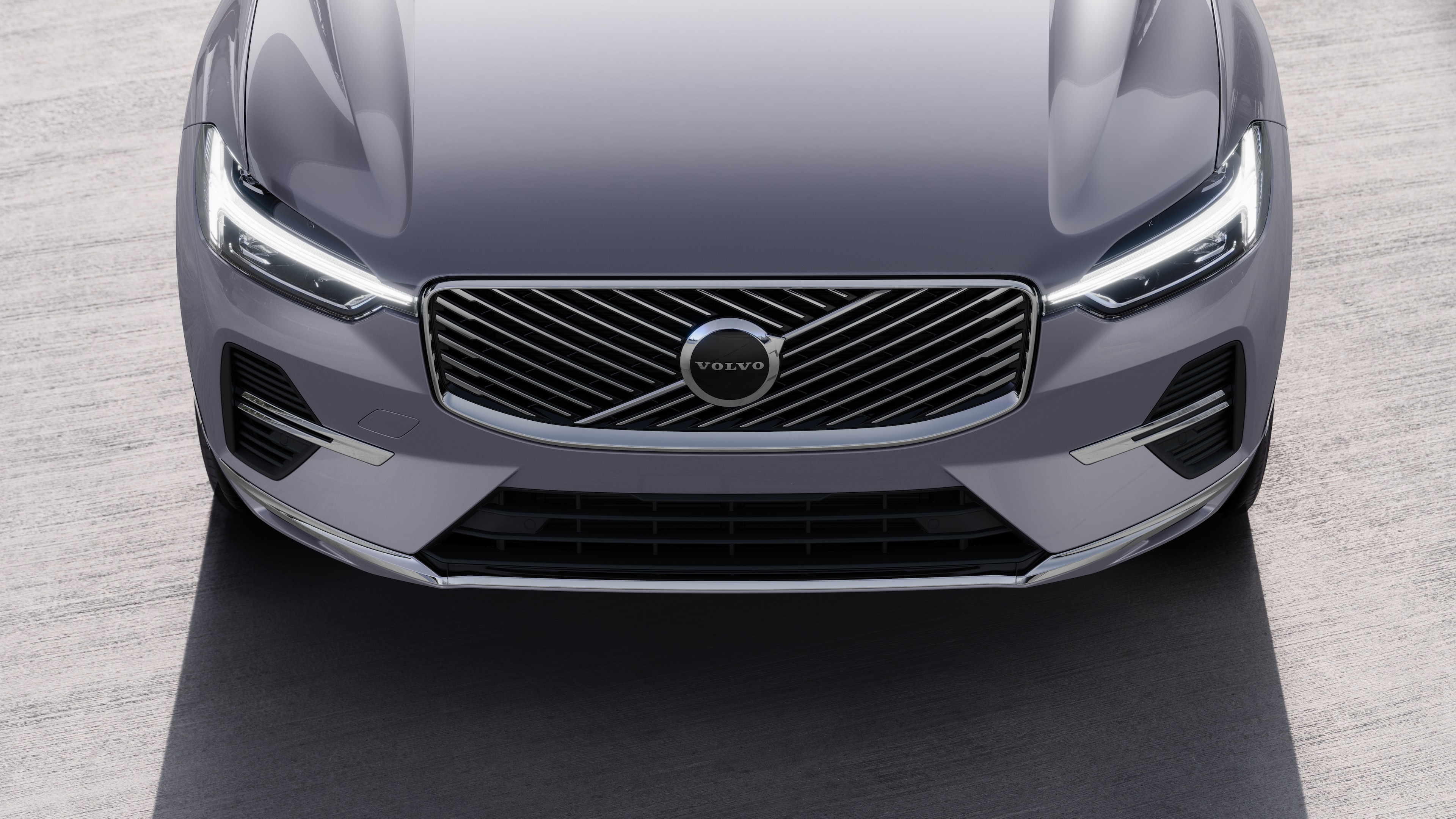 Volvo car exterior in three-quarter view on an urban street background, showing one side, roof, and part of the front.