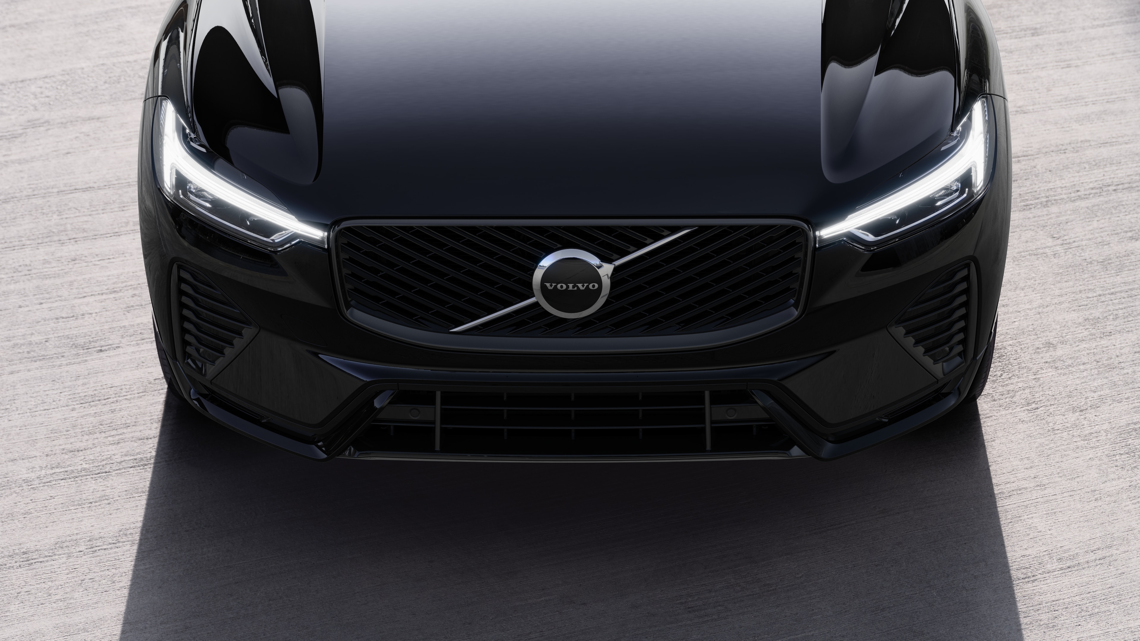 Volvo automašīnas ārpuse trīs ceturtdaļu skatā uz pilsētas ielas fona, parādot vienu pusi, jumtu un daļu priekšpuses.