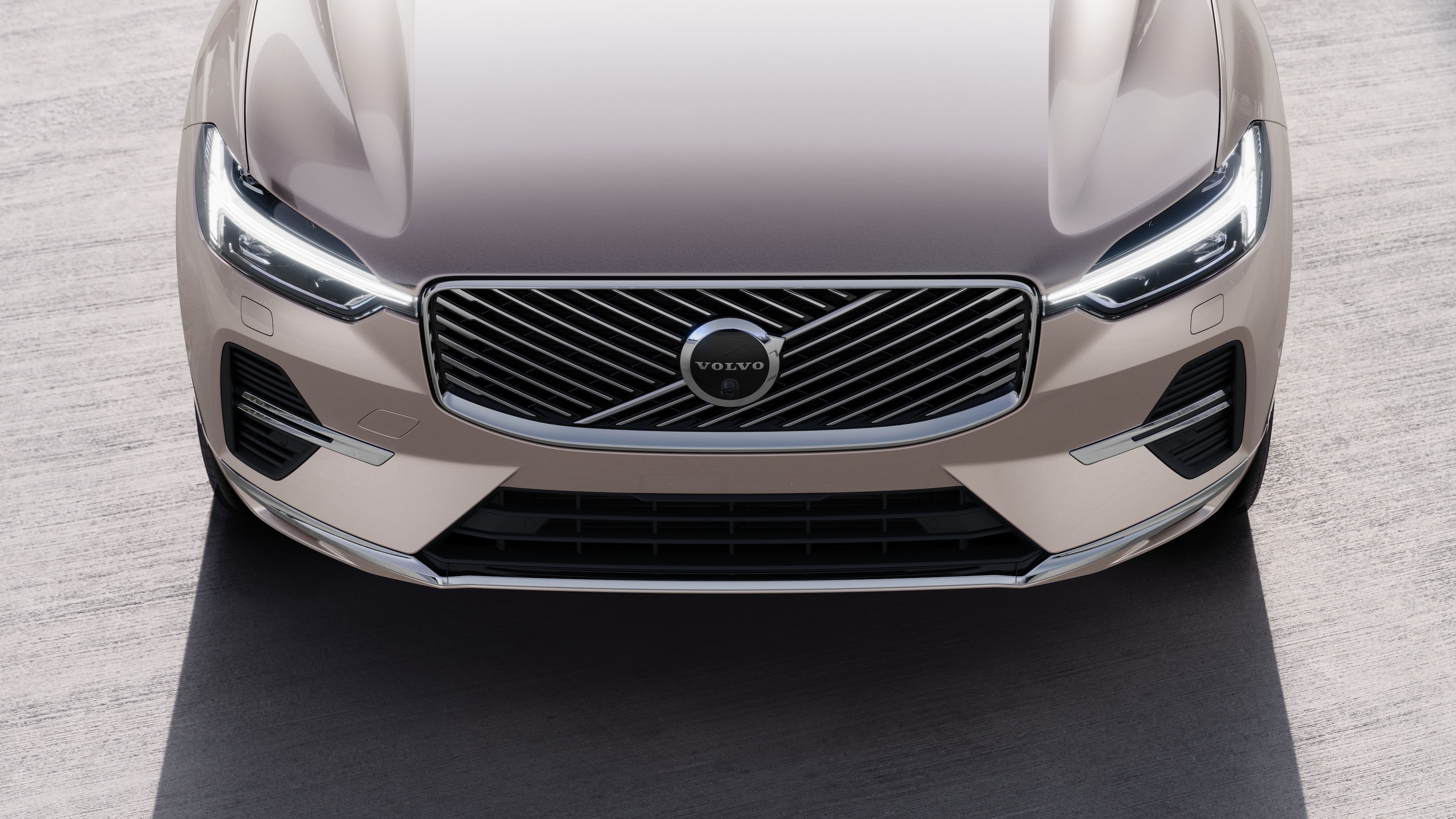 Volvo-bíll að utan í þriggja fjórðu hluta götubakgrunns í þéttbýli sem sýnir aðra hliðina, þakið og hluta framhliðarinnar.