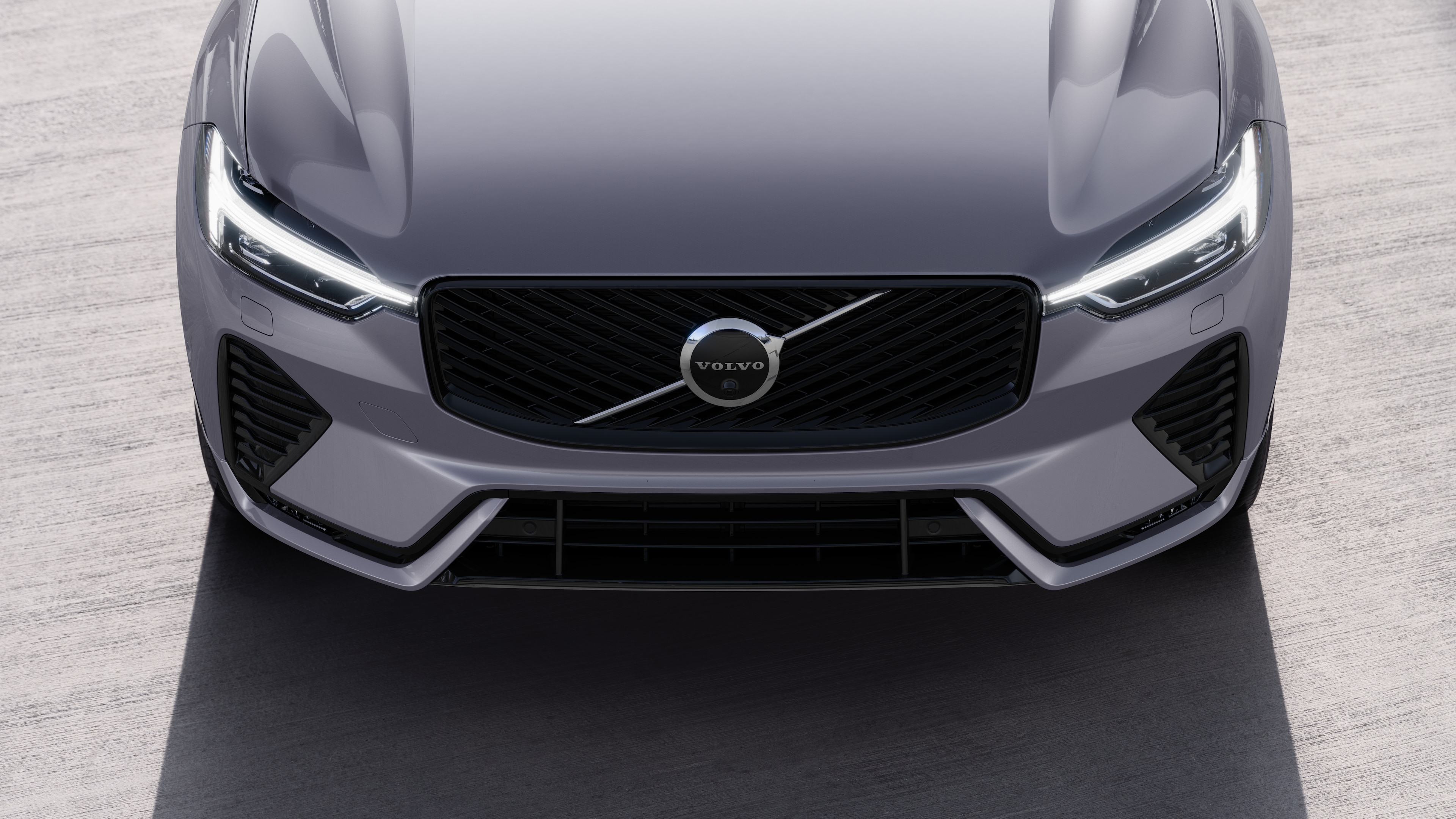 Volvo car exterior in three-quarter view on an urban street background, showing one side, roof, and part of the front.